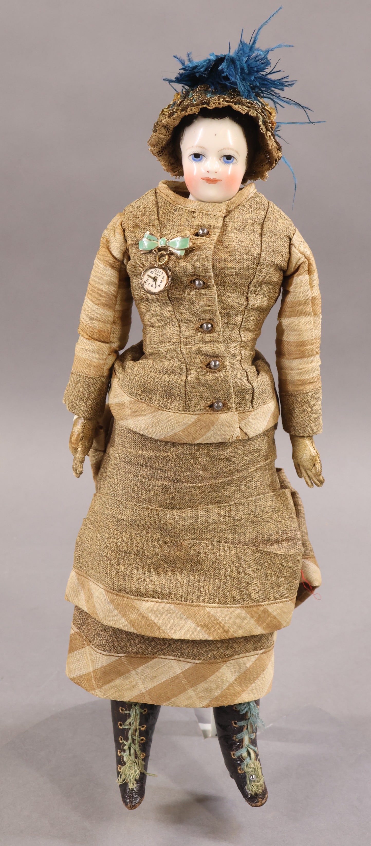 CHINA DOLLS.: 13 1/2" (FRENCH?) China shoulder head doll with painted blue eyes, short black hair. White leather fashion style body with leather arms, individual fingers. Dressed in all antique clothing - 2 pc.