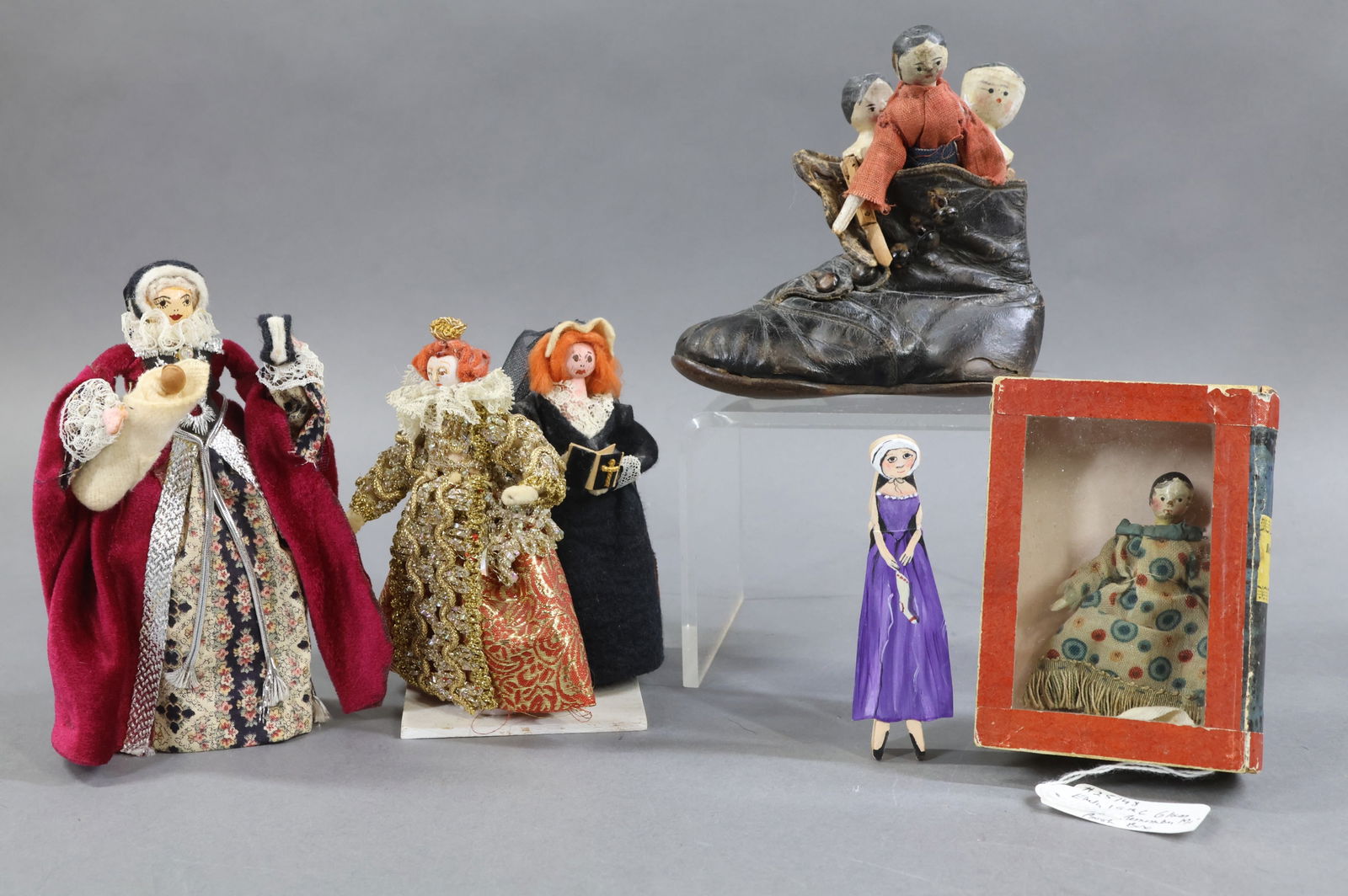 WOODEN DOLLS.: LOT of antique and artist dolls. Antique - 3" Dressed Peg wooden in an early 19th c glass front "Remember Me" book box. (3) Peg woodens 3 1/4", 4 1/4", 2" (top of torso only). They are in a leather