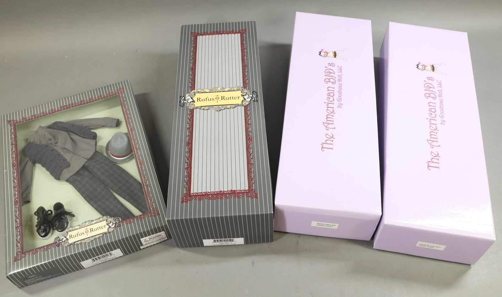 CONTEMPORARY ARTIST DOLLS.: LOT of (3) dolls, outfit. Pair of MIB THE AMERICAN BJD's by Goodreau Doll - "Secret Head Doll w/Basic Dress". "Innuende Vinyl BJD w/Basic Dress". Also - Rufus Rutter by WILDE IMAGINATION. Doll -