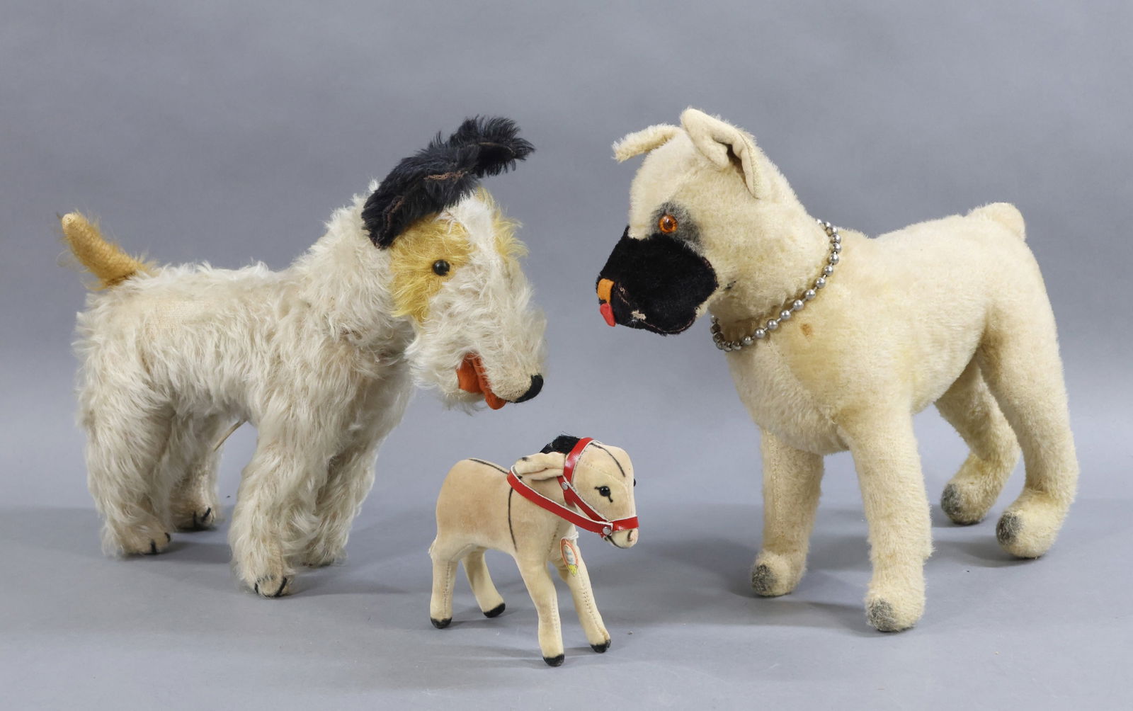 VINTAGE ANIMALS/STEIFF.: LOT. STEIFF - 5" Velveteen "Donkey", black glass eyes, leather tack, paper chest tag. OTHER - Pair of mohair dogs. 11" T Tagged KNICKERBOCKER "Boxer" with swivel head, plastic eyes. Condition: age