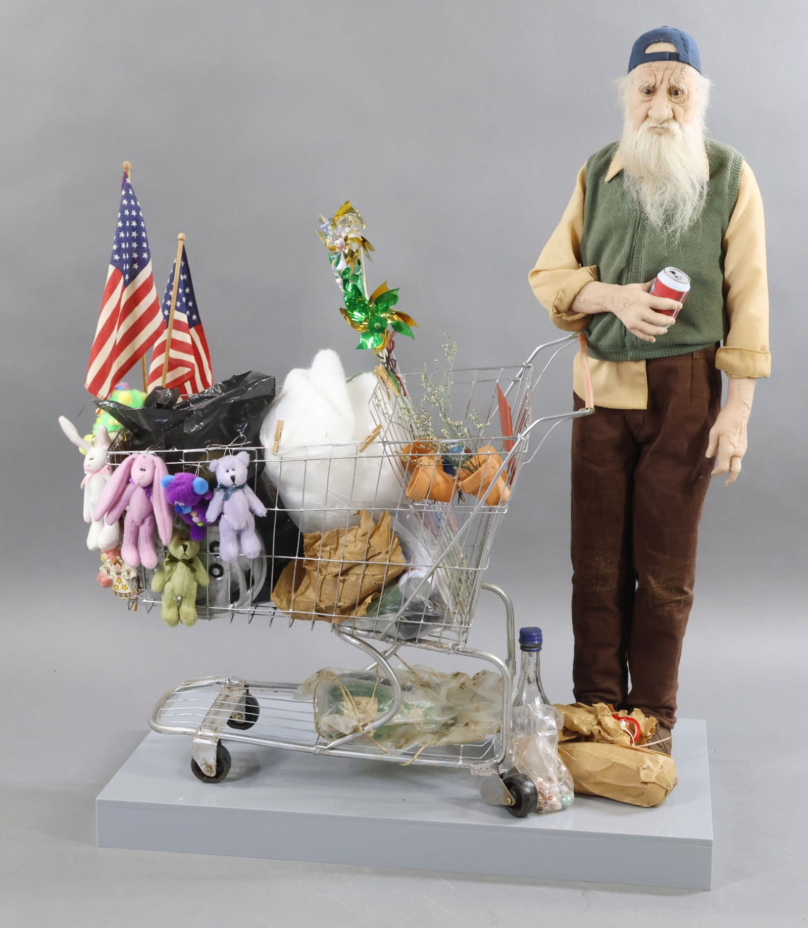 ARTIST DOLLS.: 22" T "Kazam" by NIADA artist Lisa Lichtenfels. Standing on his base, that is 18" x 11". "Kazam" has his "treasures" that he has collected with him in the grocery cart. He is made from nylon which is