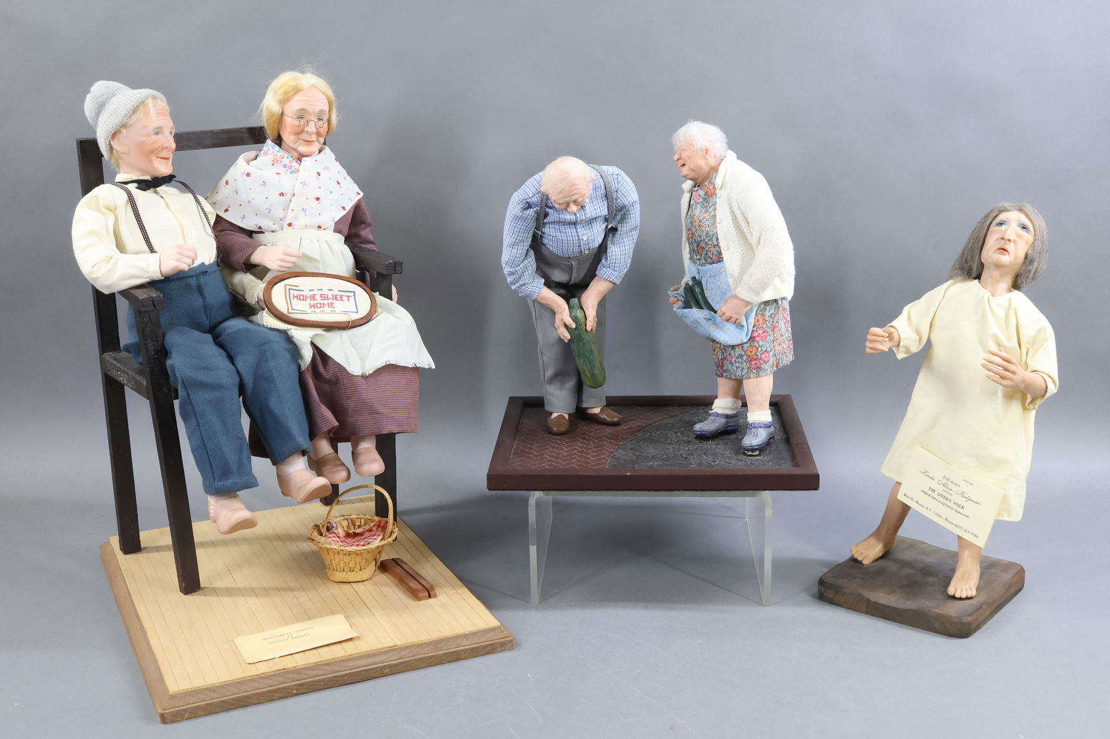 ARTIST DOLLS.: LOT. Scene 1) 1981 "Happiness Starts in Loving Hearts" by artist Barbara Peterson. Pair of 16 1/2" bisque shoulder head dolls sitting on a settee. She is stitching a "Home Sweet Home" sampler. Wooden