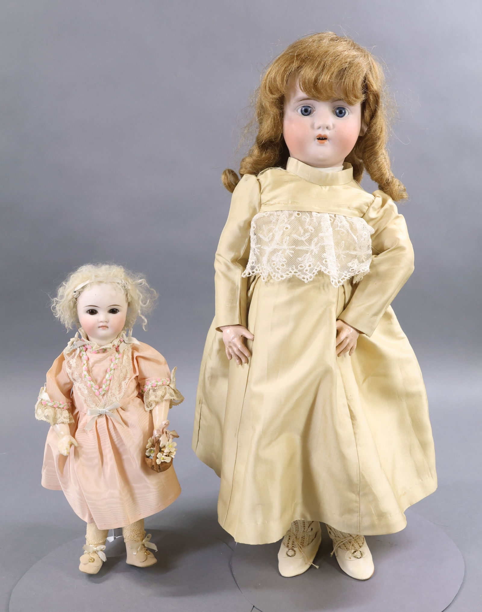GERMAN/FRENCH BISQUE DOLLS.: Pair of dolls. GERMAN - 12" "5" Solid dome doll with stationary brown eyes, CLOSED MOUTH, white fur wig. Very nice coloring. Papier mache ball jointed body with 1 pc. lower arms. Dressed in vintage/an