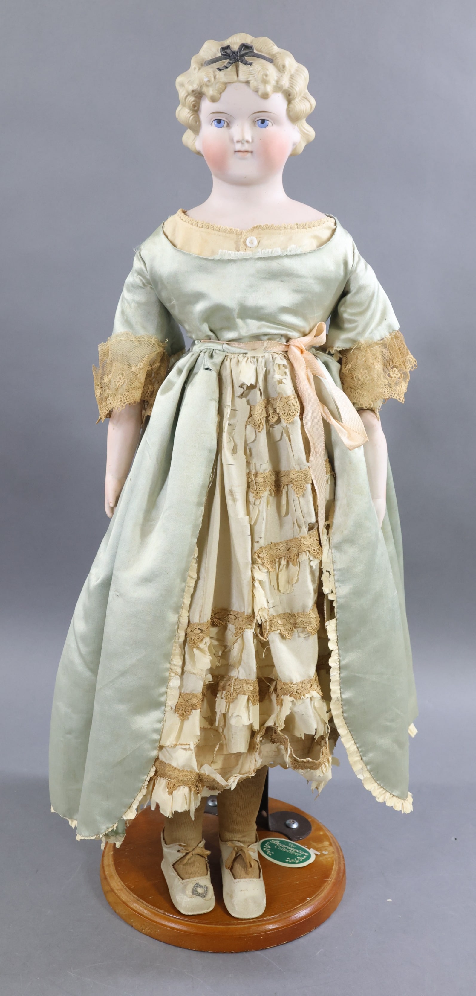 GERMAN BISQUE DOLLS.: 24" "10" Shoulder head doll with painted, molded features and hair. Blue eyes, closed mouth, blonde curly hair. Painted black bow on front Band on back of head has not been painted. Leather body with