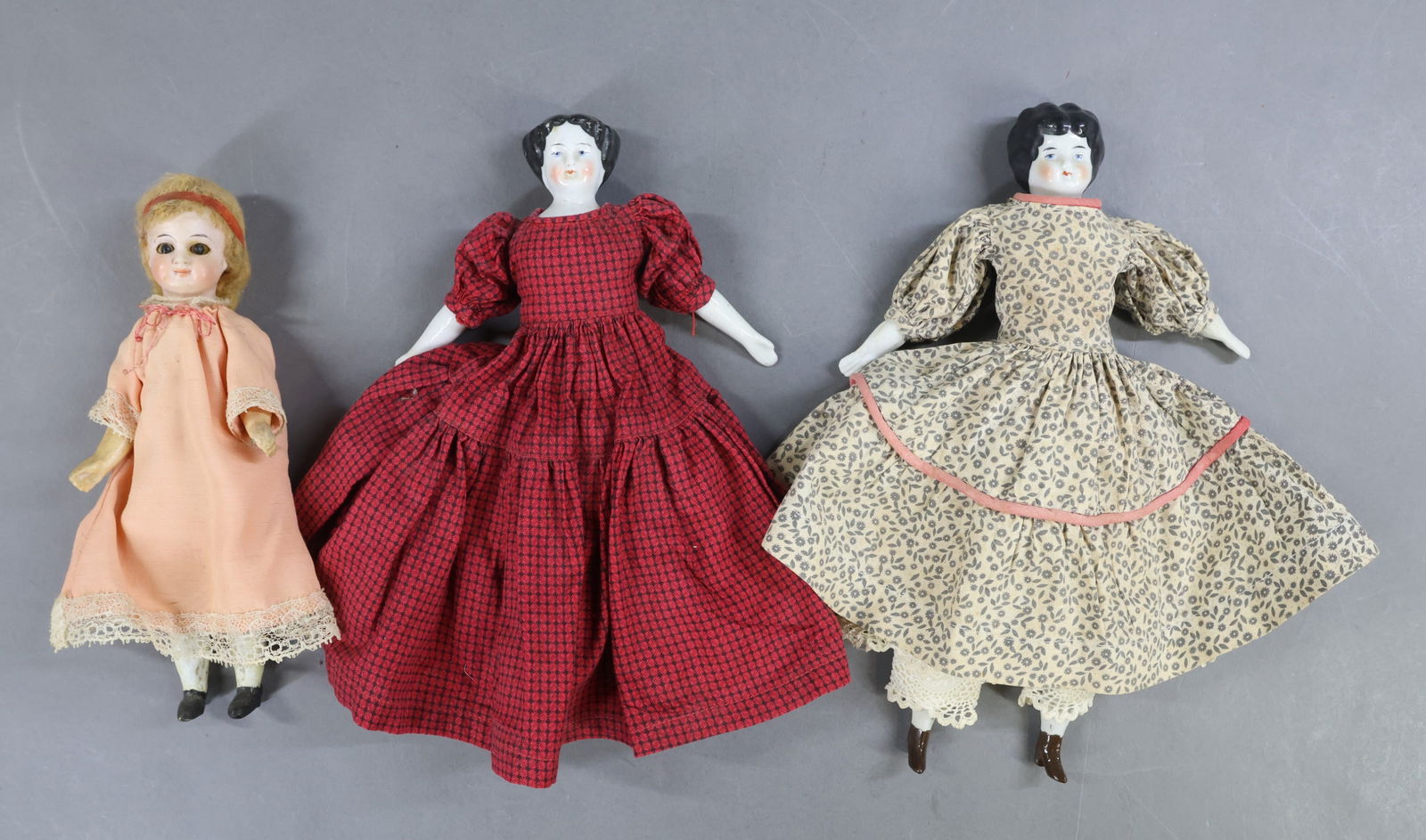 PARIAN/CHINA DOLLS/OTHER.: LOT of (3) dolls. Pair of China shoulder head dolls. Both have black center part hair, blue eyes. 10" Low Brow with cloth body, unglazed lower limbs. Vintage/antique clothing. 9" Flat top style with c