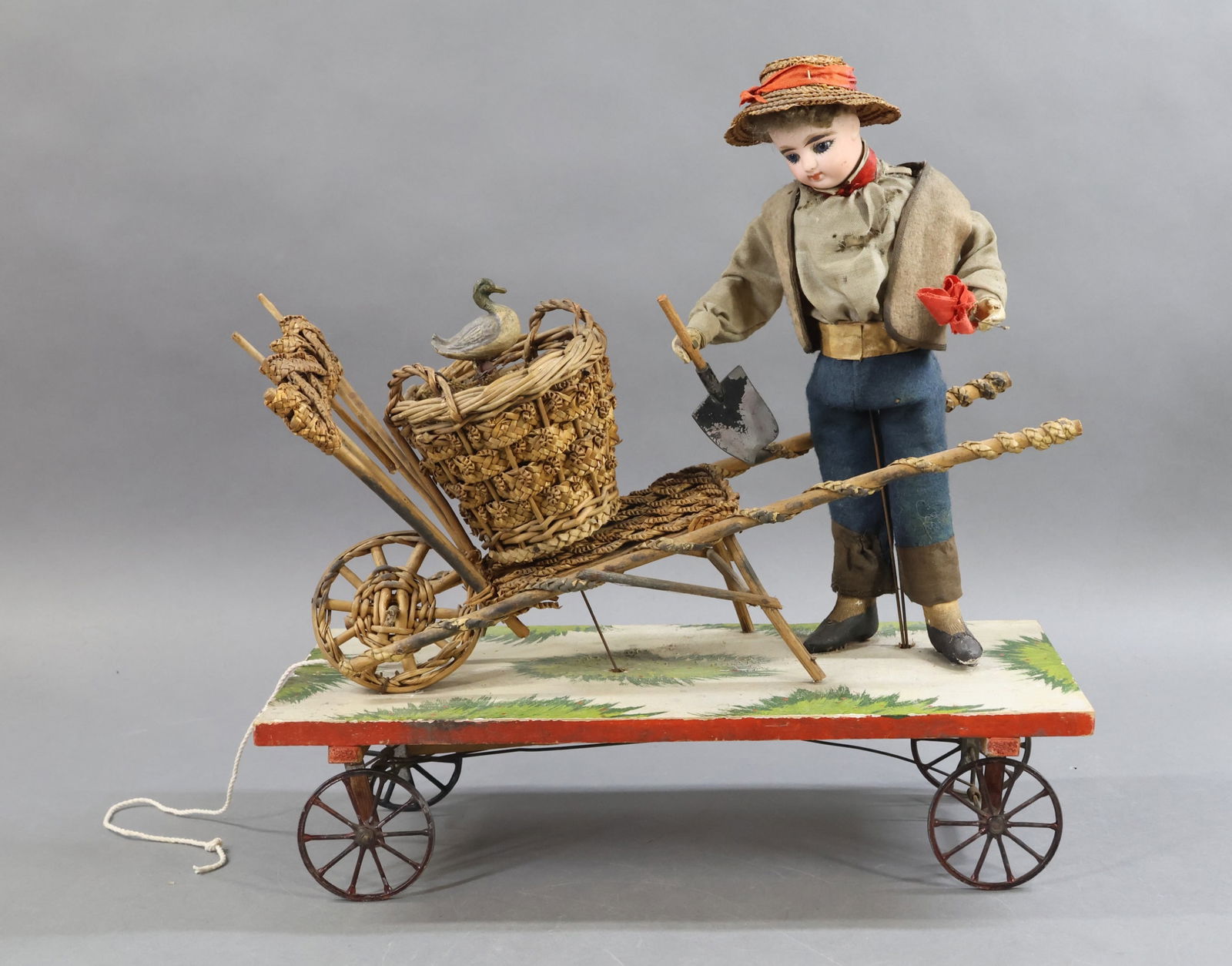 TOYS - ANTIQUE.: Antique Platform Pull Toy. 12" F.G. French bisque head doll with stationary blue eyes, closed mouth, short curly honey blonde mohair wig. Wire armature body with wooden lower arms, papier mache lower