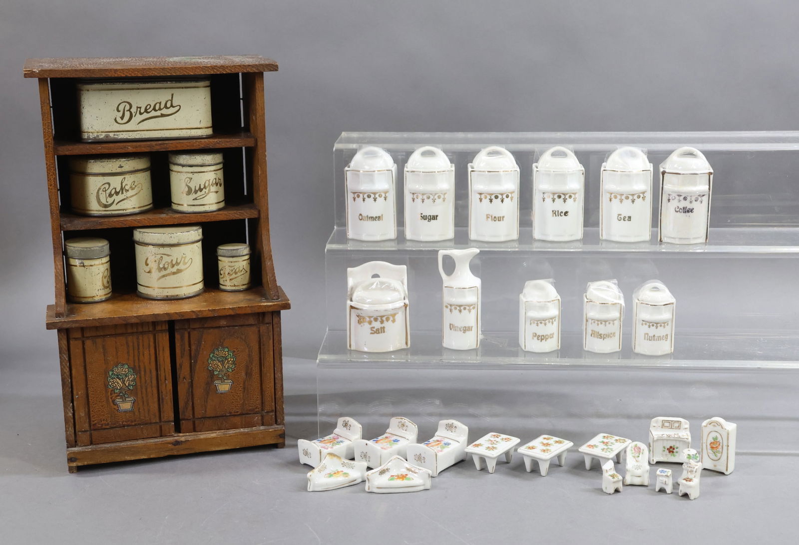 MINIATURES.: LOT of LARGER SIZE SCALE items. Set of German china, 11 pc. lidded canister set, vinegar (no oil). Vinegar is 3 1/4". Set is white with gold letters. 12" Wooden (oak?) child's cupboard with set of