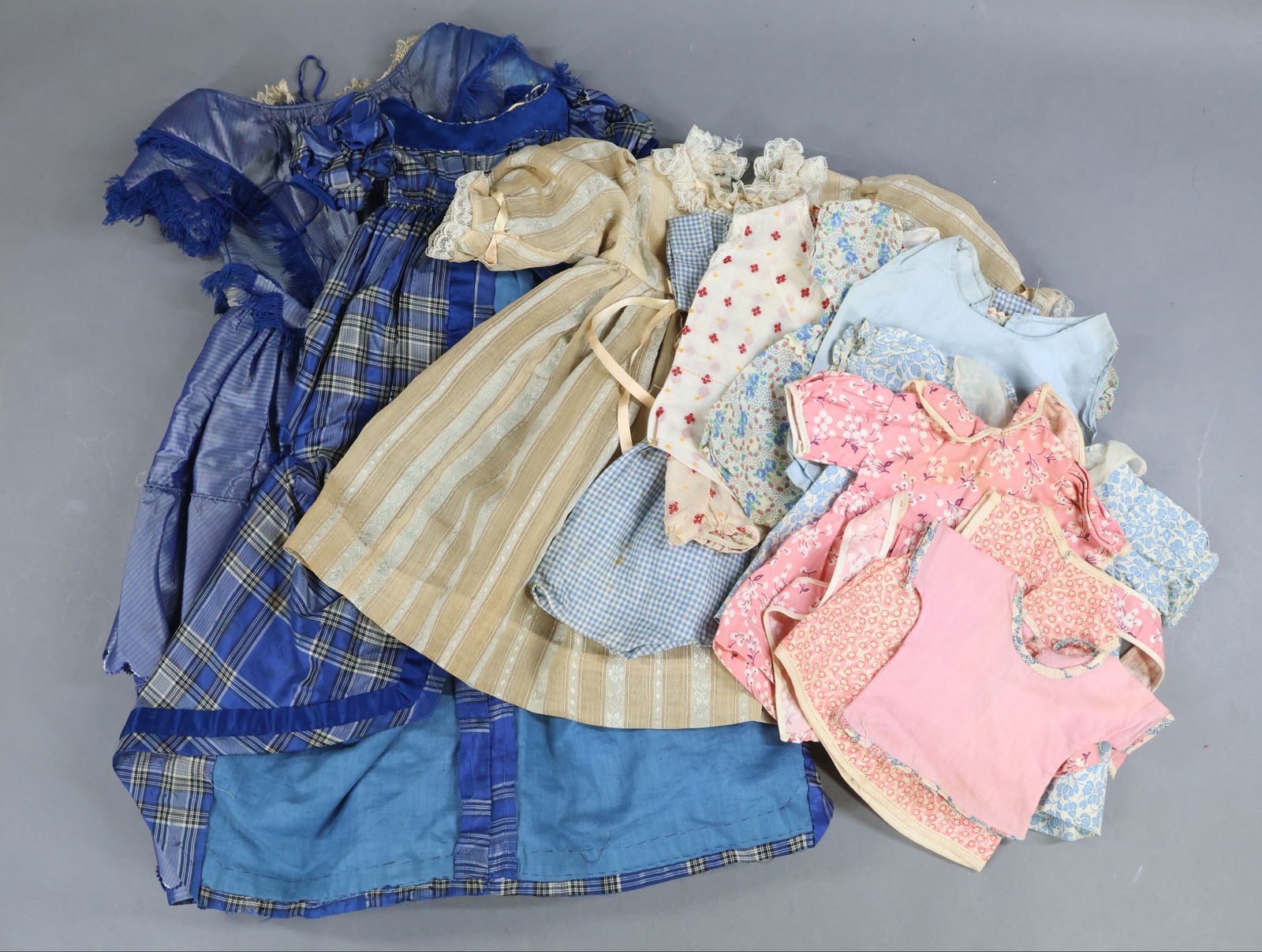 ANTIQUE CLOTHING, ACCESSORIES.: LOT of DOLL clothing. Antique - 22" L. blue silk period gown with blue silk fringe detail on bodice. 19" Blue plaid silk period dress with satin ribbon detail. This would go over a separate skirt as