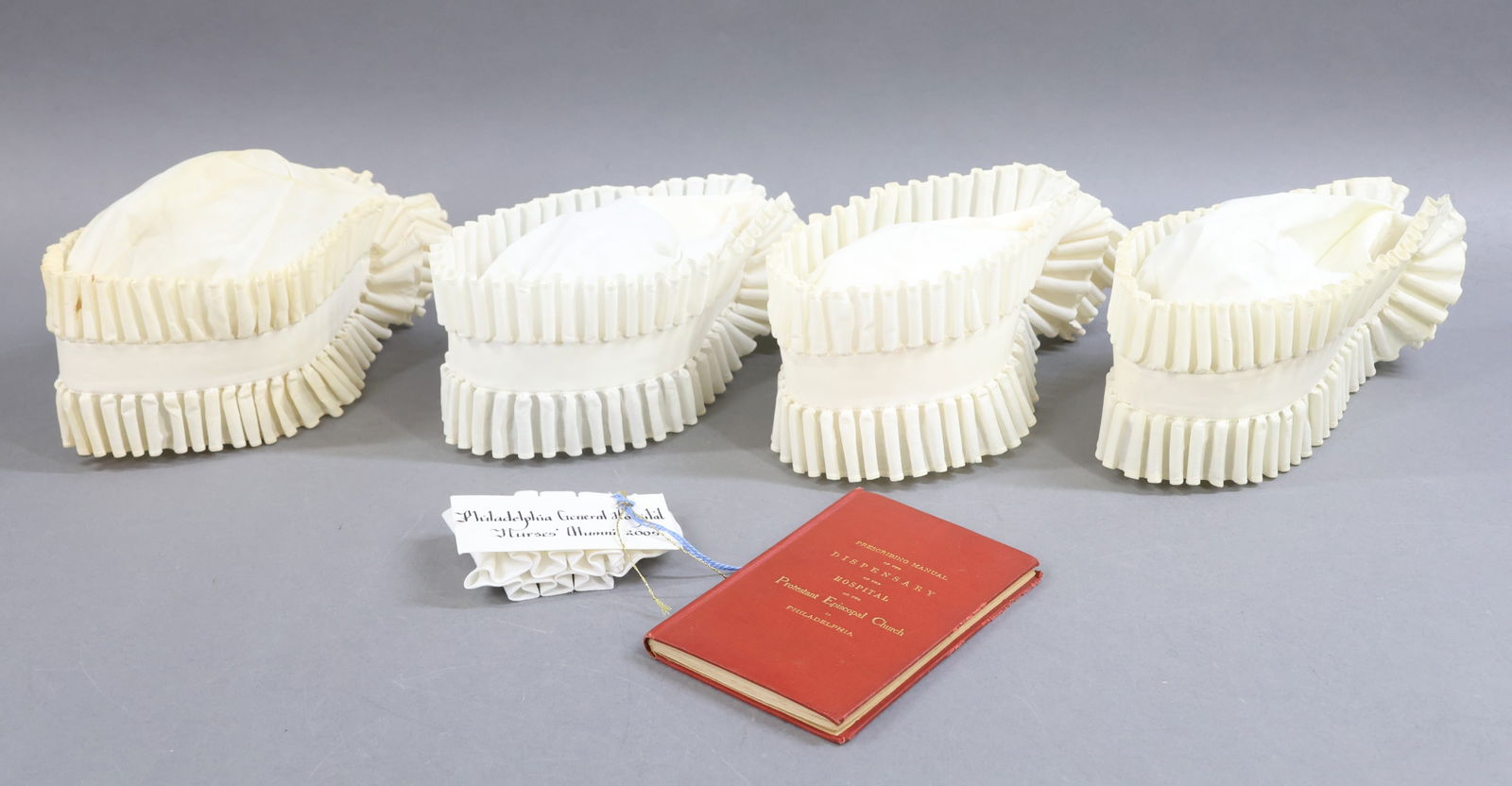 ANTIQUE CLOTHING, ACCESSORIES.: LOT. (4) Ladies' NURSING caps. (One is marked C. Zagaroli, (2) Irene Vinchur, Jane L. Scott.) (1) Miniature cap from the Philadelphia General hospital Nurses' Alumni 2005. Book - "Prescribing Manual