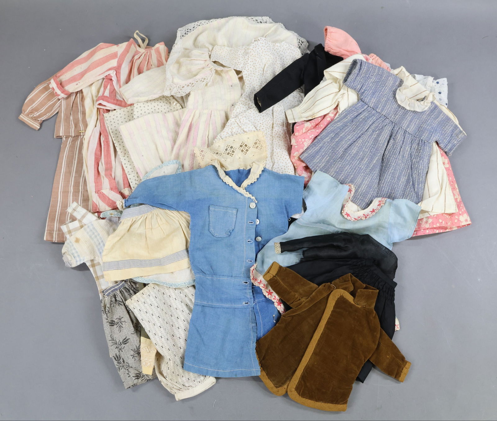 ANTIQUE CLOTHING, ACCESSORIES.: LOT of antique DOLL clothing. Cotton prints - 2 pc. PJ sets, 2 pc. blouse/skirt. Dresses. Skirts, pantaloons. Aprons. Solid color cotton - dress, romper. Velveteen coat. Silk - blouse, skirt. Black wo