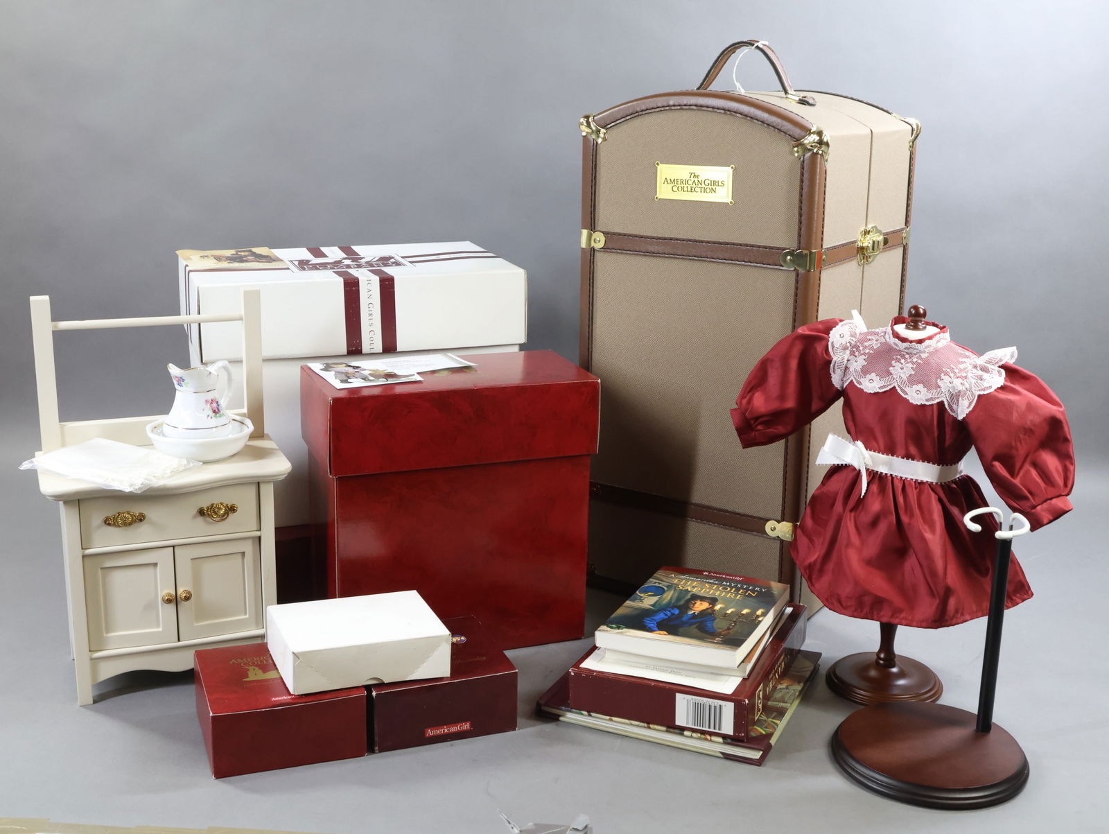 AMERICAN GIRLS.: LOT of SAMANTHA. The American Girl Collection Trunk with large wardrobe of clothing, accessories. Brass Bed. Commode with china pitcher/bowl. (Drawer pulling missing on commode.) School Desk. Book Str