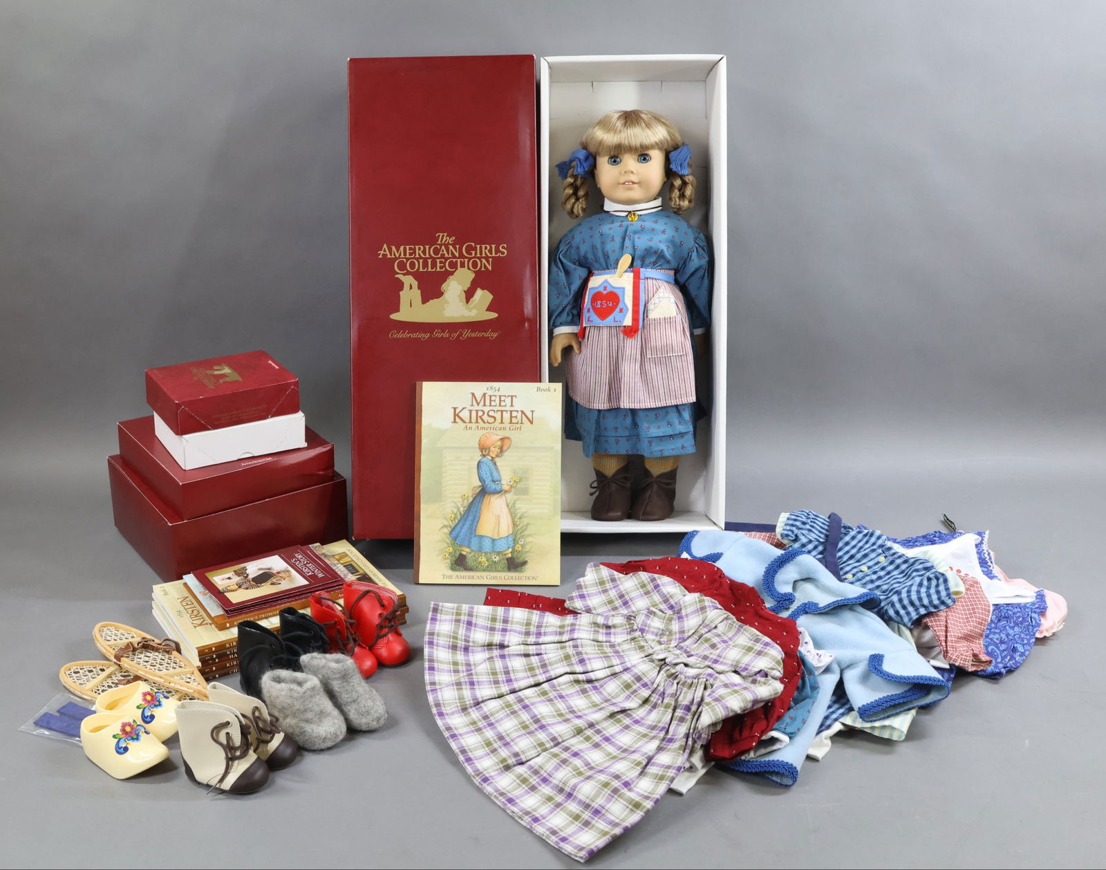 AMERICAN GIRLS.: LOT of KIRSTEN. Doll in OB w/book. Large wardrobe of clothing, accessories. Kirsten's Doll. Framed Picture. Books 2, 3, 4, 5, 6. (1) Short Stories Book. Condition: outfits may not be complete. This