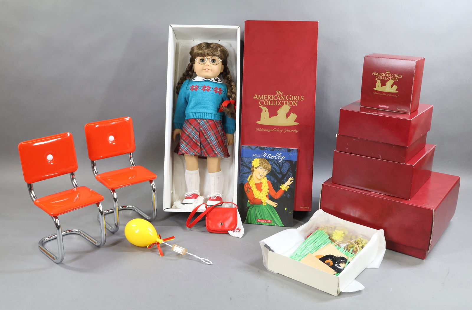 AMERICAN GIRLS.: LOT of MOLLY. Doll in OB w/book. Happy Birthday Molly - (2) Chrome Chairs. Party Games. Birthday Crowns. Balloon. China Tea Set. 2) Halloween Hawaiian Grass Skirt Sets. Bennett, The Dog. This lot is b