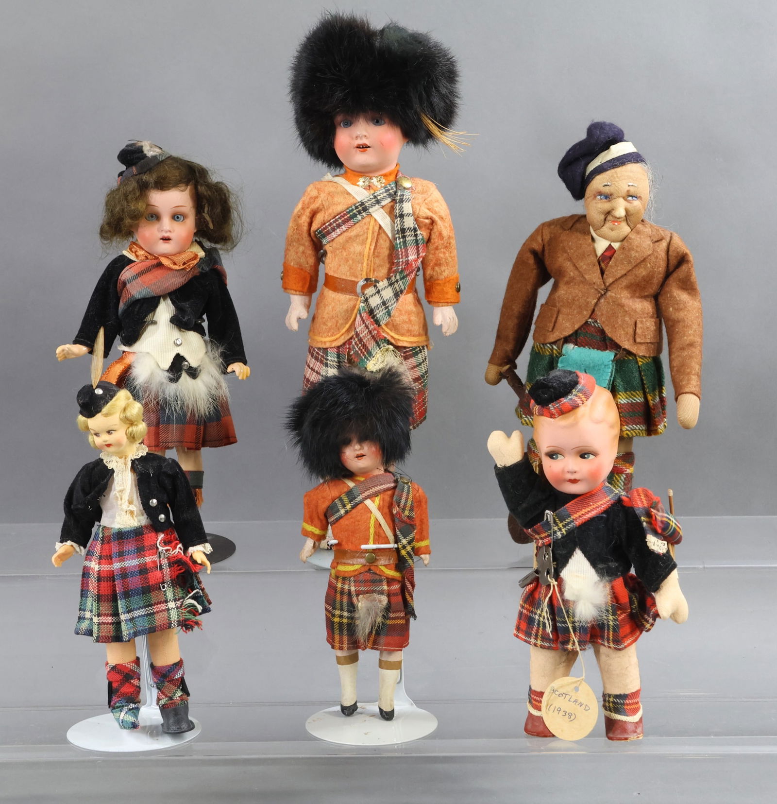 ENGLISH/BRITISH ISLES DOLLS.: LOT of (6) antique dolls dressed in Scottish attire. (3) GERMAN painted bisque dolls. All of them have open mouths, 5 pc. papier mache bodies with painted shoes, all original clothing and fur sporns.