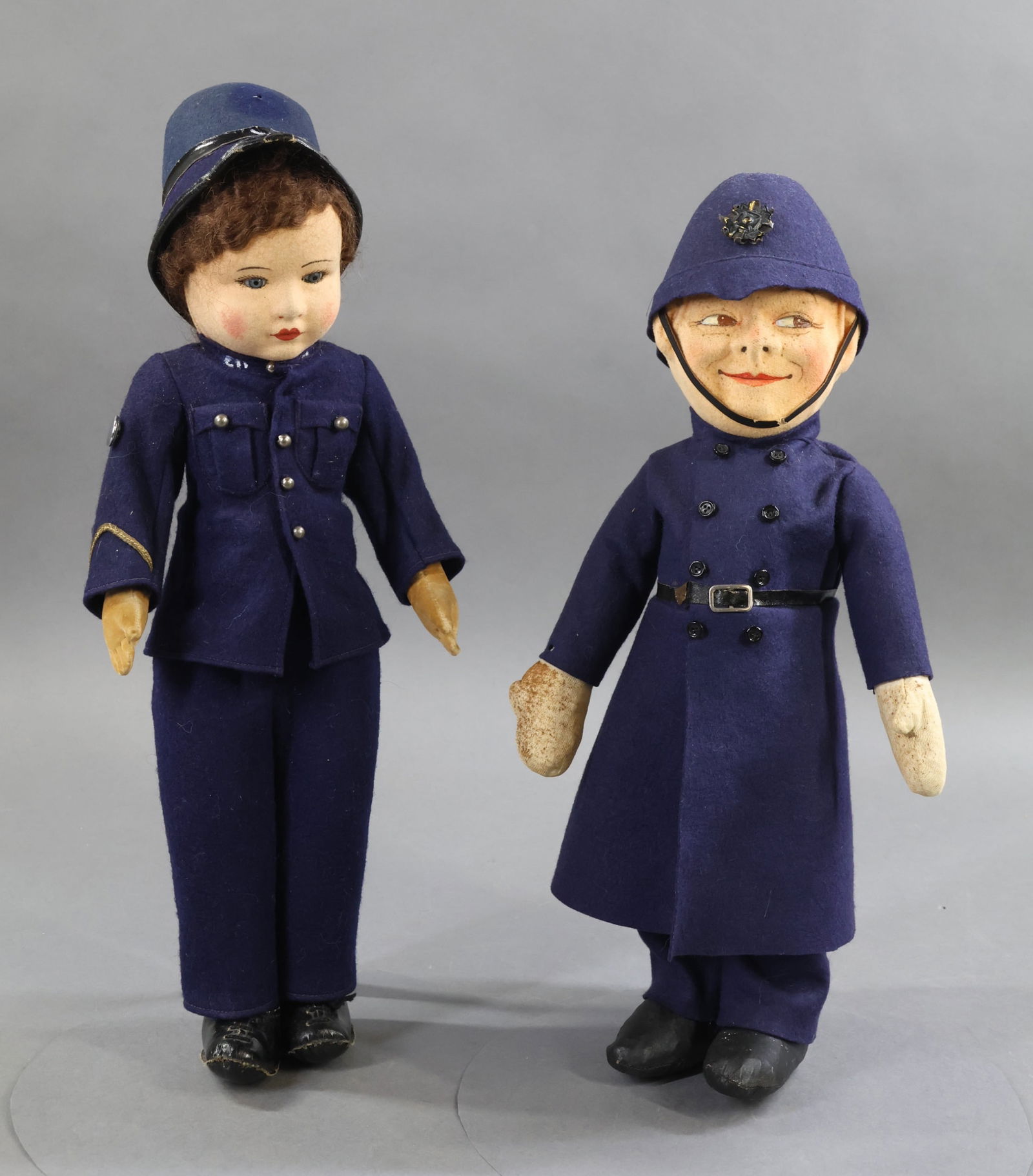 ENGLISH DOLLS.: Pair of Male Police dolls. Doll 1) 16" CHAD VALLEY Policeman with felt face, blue glass eyes, brown mohair wig. Velveteen body. Dressed in original navy blue wool uniform, molded felt hat, black oilcl
