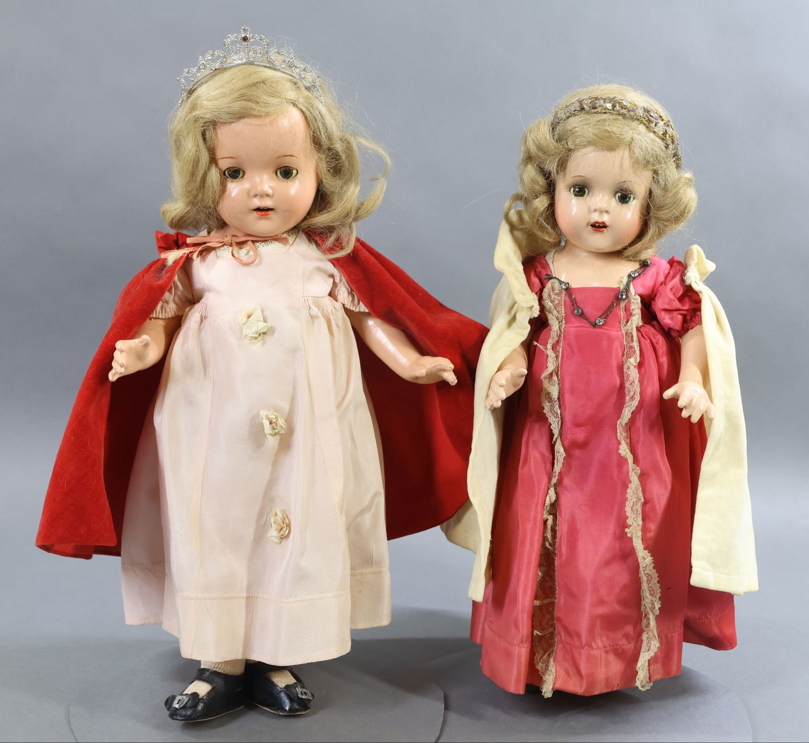 ROYAL DOLLS - MADAME ALEXANDER.: Pair of tagged 1937 composition "Princess Elizabeth" dolls. Both dolls have sleep eyes, honey blonde HH wigs. They each are wearing original tagged clothing. (1) Has her metal tiara, the other has