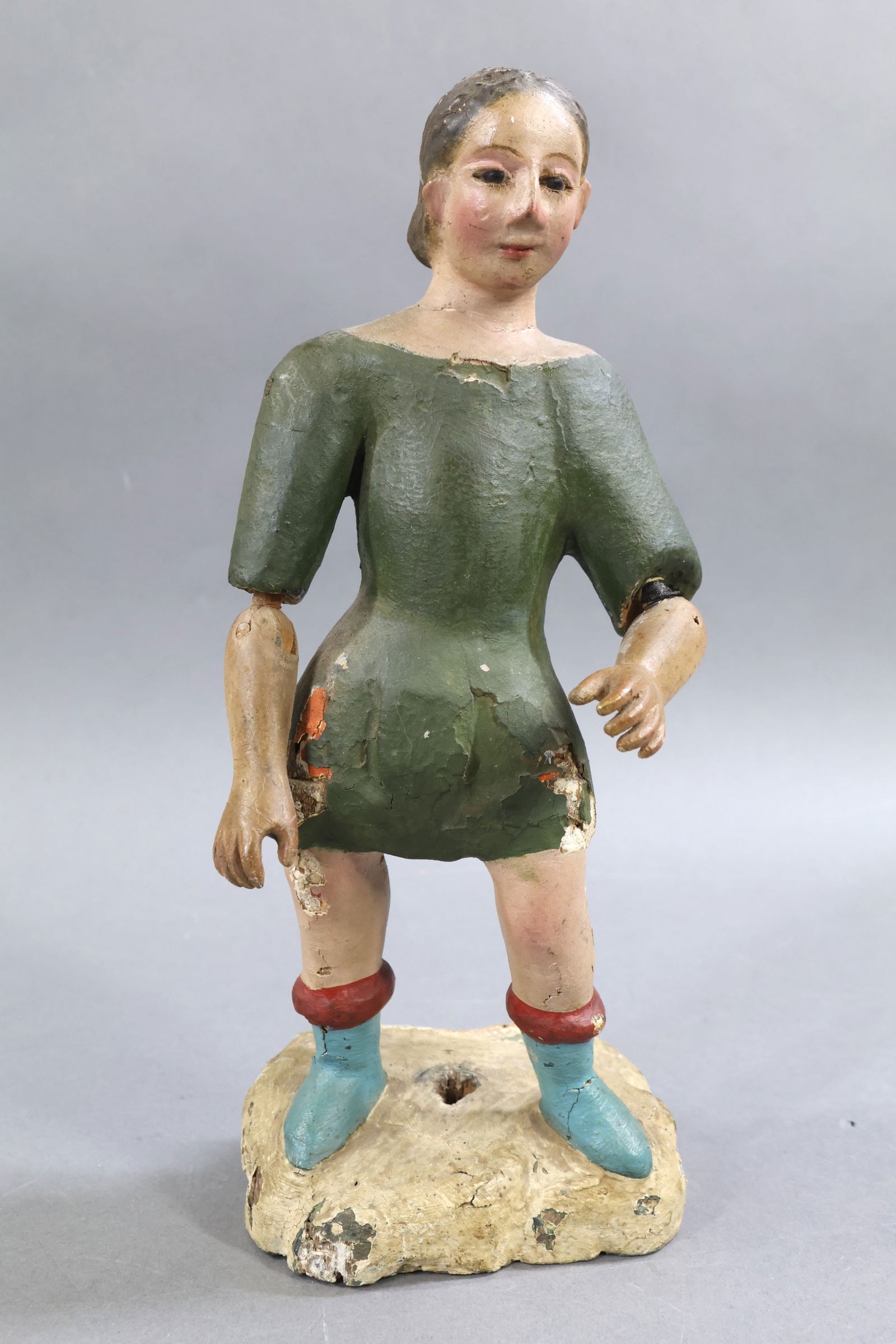 SANTOS FIGURE.: 10" Spanish SANTOS articulated figure, possibly from a Creche. Stationary glass eyes. Articulated elbow joint. Figure stands on a wood base. Condition: age loss. May have some possible repaint. This