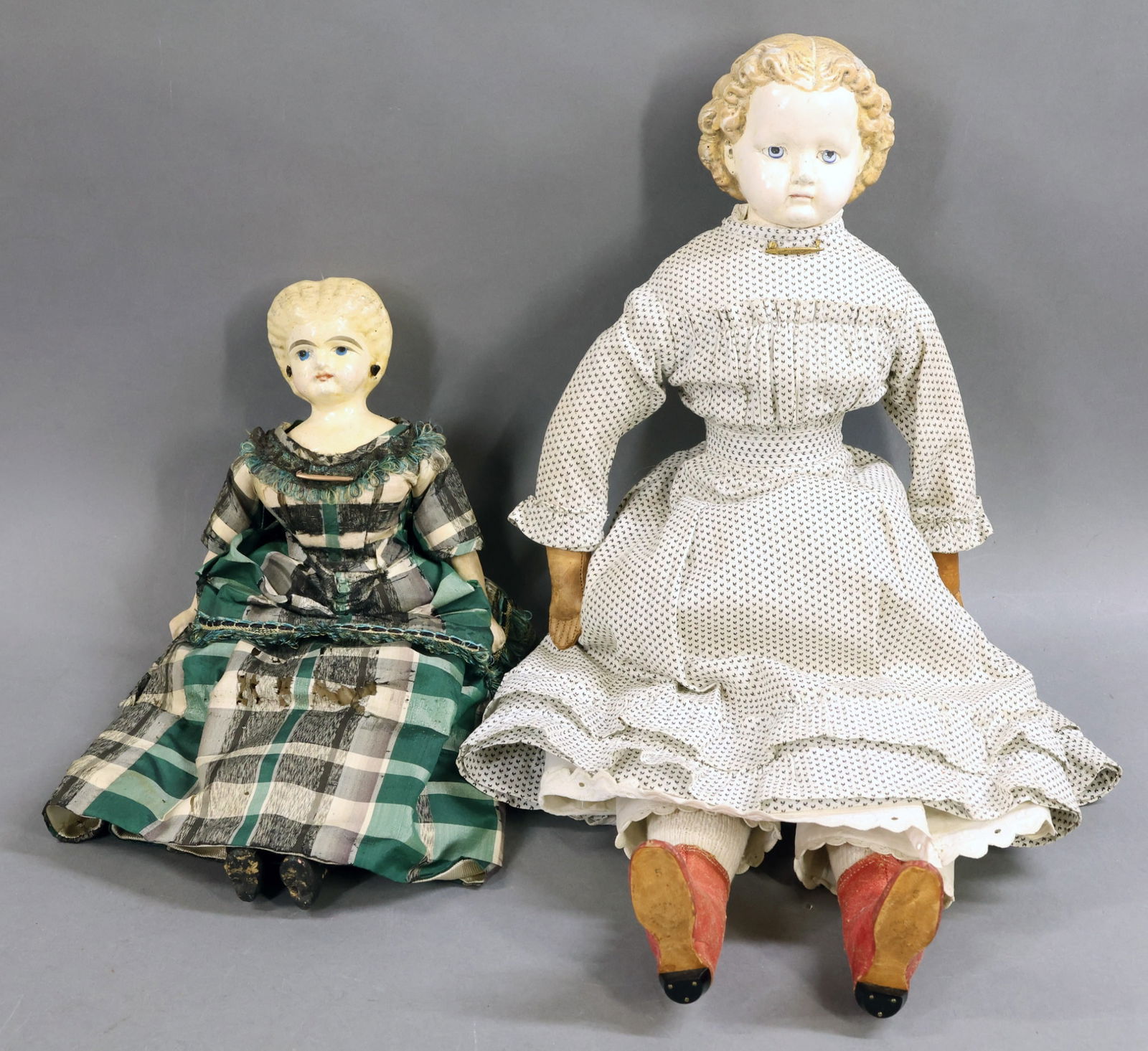 PAPIER MACHE DOLLS.: Pair of blonde shoulder head dolls. Both dolls have painted blue eyes, closed mouths. Molded, painted hair. They have antique cloth bodies. They are both dressed in antique clothing. Doll 1) 13