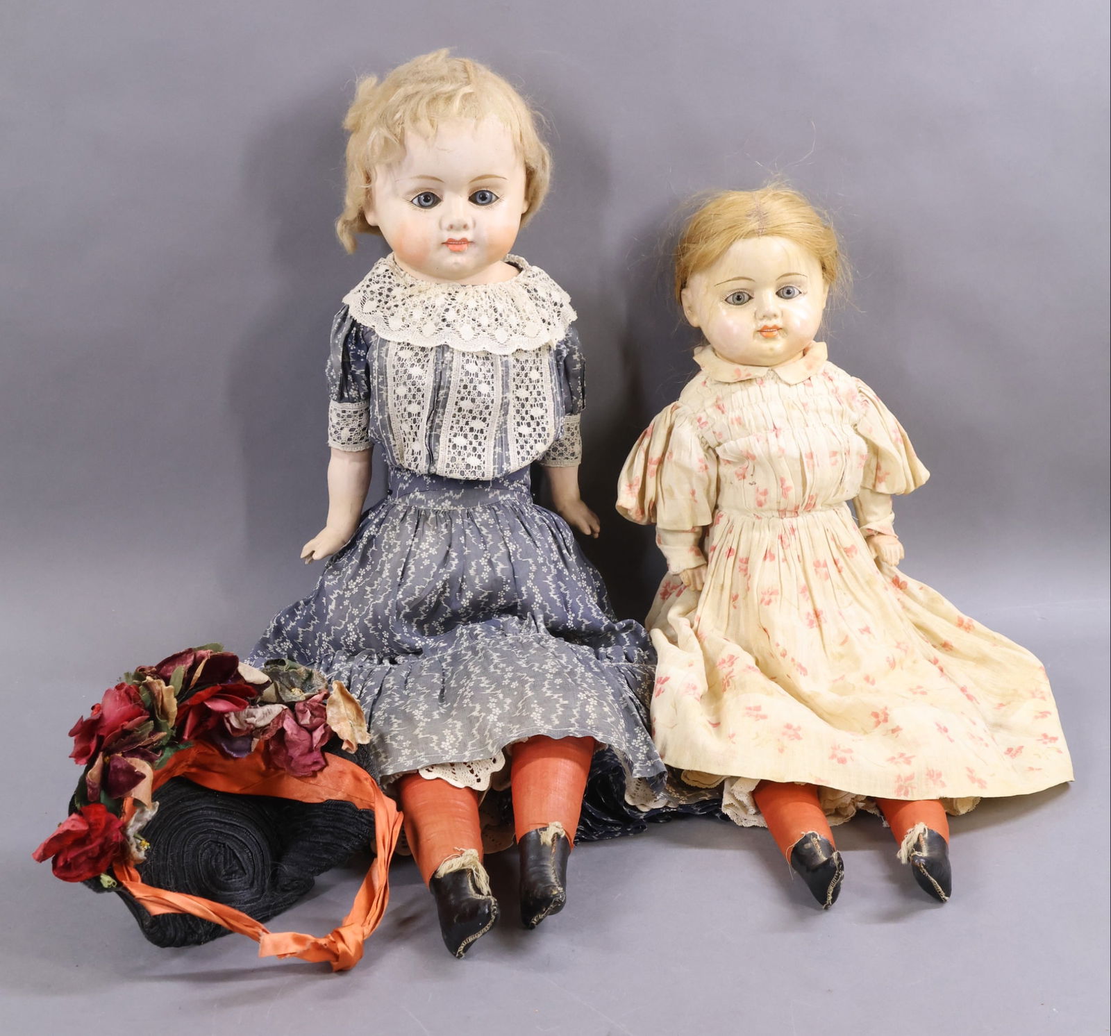 PAPIER MACHE DOLLS.: Pair of PATENT WASHABLE dolls. Both dolls have stationary blue glass eyes, open/closed mouths with row of painted teeth. Cloth bodies with papier mache lower arms. Both dolls have red lower cloth