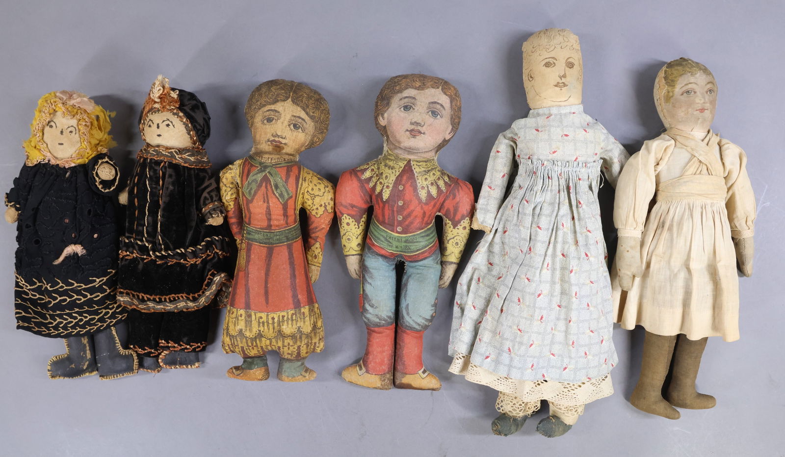 CLOTH DOLLS.: LOT of (6) antique dolls. Pair of 12" Printed cloth boy and girl dolls marked: PATENT 36080 Sept. 16th, 1902. 13 1/2" BRUCKNER doll. (Missing hair/bonnet.) 15 1/2" Handmade OOAK doll with features,