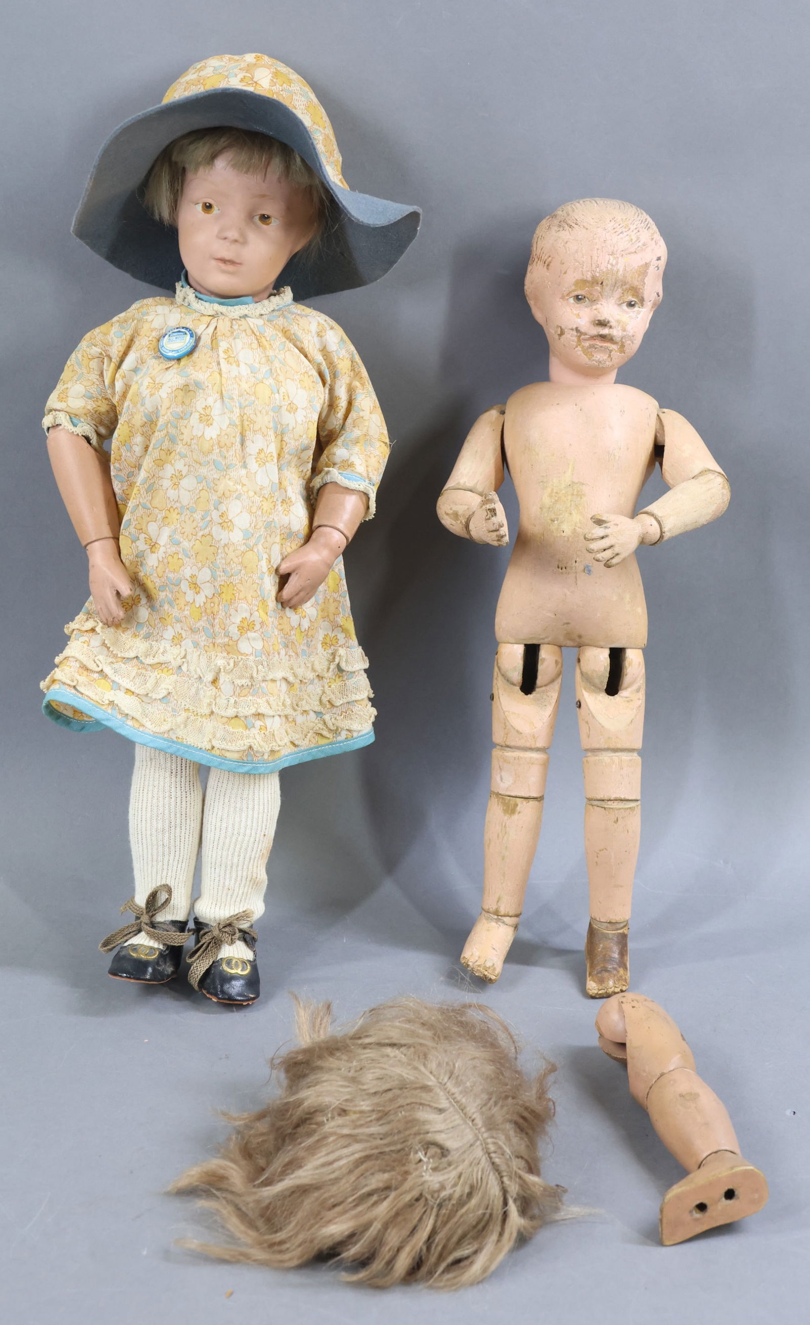 SCHOENHUT.: LOT. Pair of dolls and extra parts. Doll 1) 16" Model No. 301, 1911-1924. Brown intaglio eyes, original tosca mohair wig. Oval decal on back of torso. No original clothing, dressed in vintage cotton