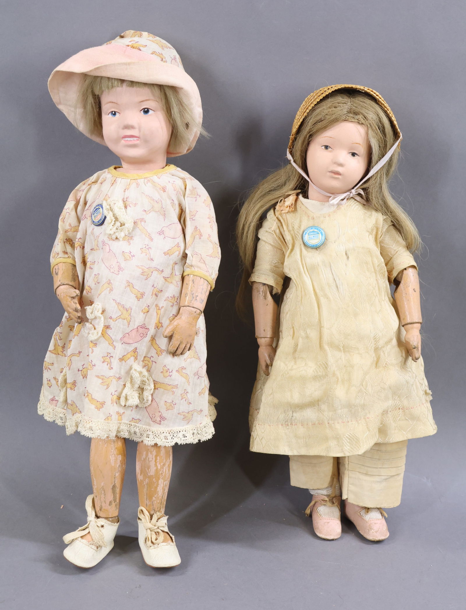 SCHOENHUT.: Pair of dolls. Both dolls have intaglio eyes, and have the incised mark on the back of their torsos. Doll 1) 14" Model No. 312, 1917-1924. Brown eyes, replaced antique honey blonde HH wig. No