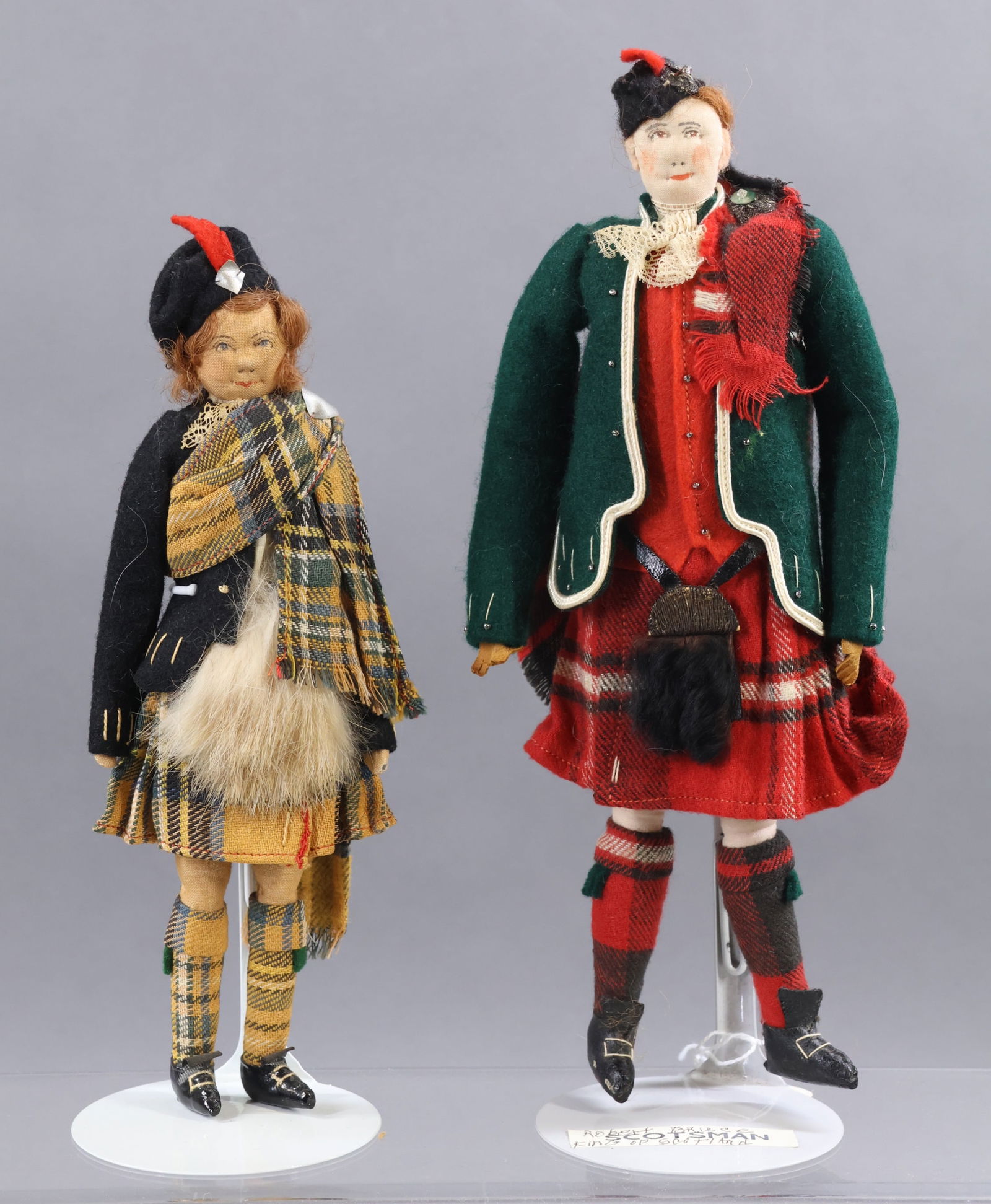 LIBERTY OF LONDON.: Pair of tagged dolls dressed in Scottish outfits. 8 1/2" Female child dressed in Stewart plaid with fur sporn. 10" "Robert Bruce" the heroic King of the Scots (1306-1329) who secured Scotland's wide-p