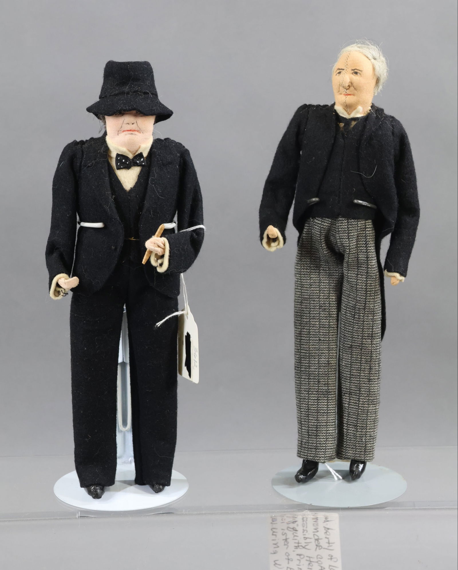 LIBERTY OF LONDON.: Pair of tagged male dolls. "Winston Churchill" and (possibly) "Herbert H. Asquith", Prime Minister of England during WWI 1908-1916. (Seam down center of face.) (2) Stands. Condition: H. Asquith doll h