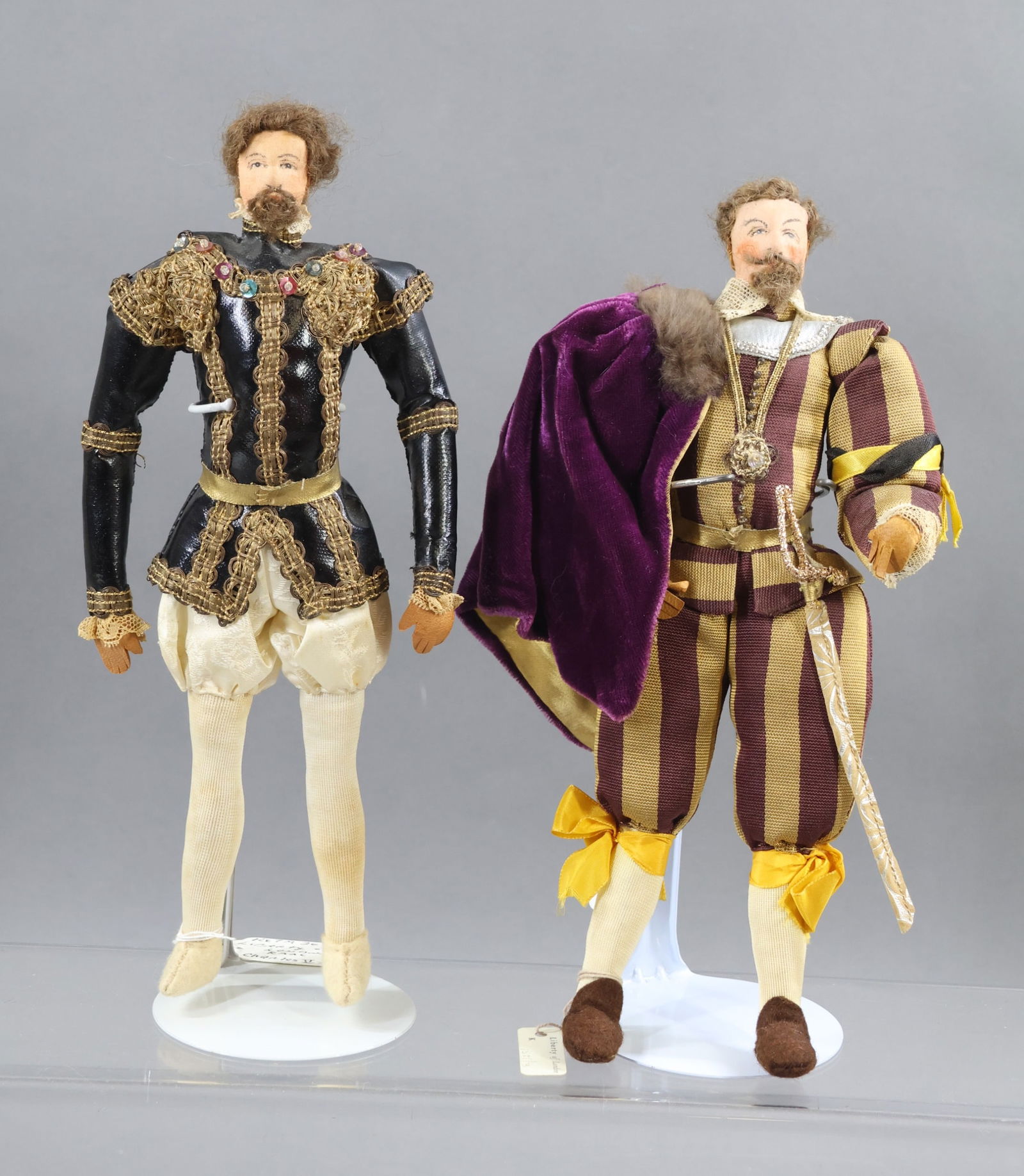 LIBERTY OF LONDON.: Pair of tagged male dolls. "Charles II, Spain". "Sir Francis Drake". (2) Stands. Condition: minor age discoloration. This lot is being sold AS IS.