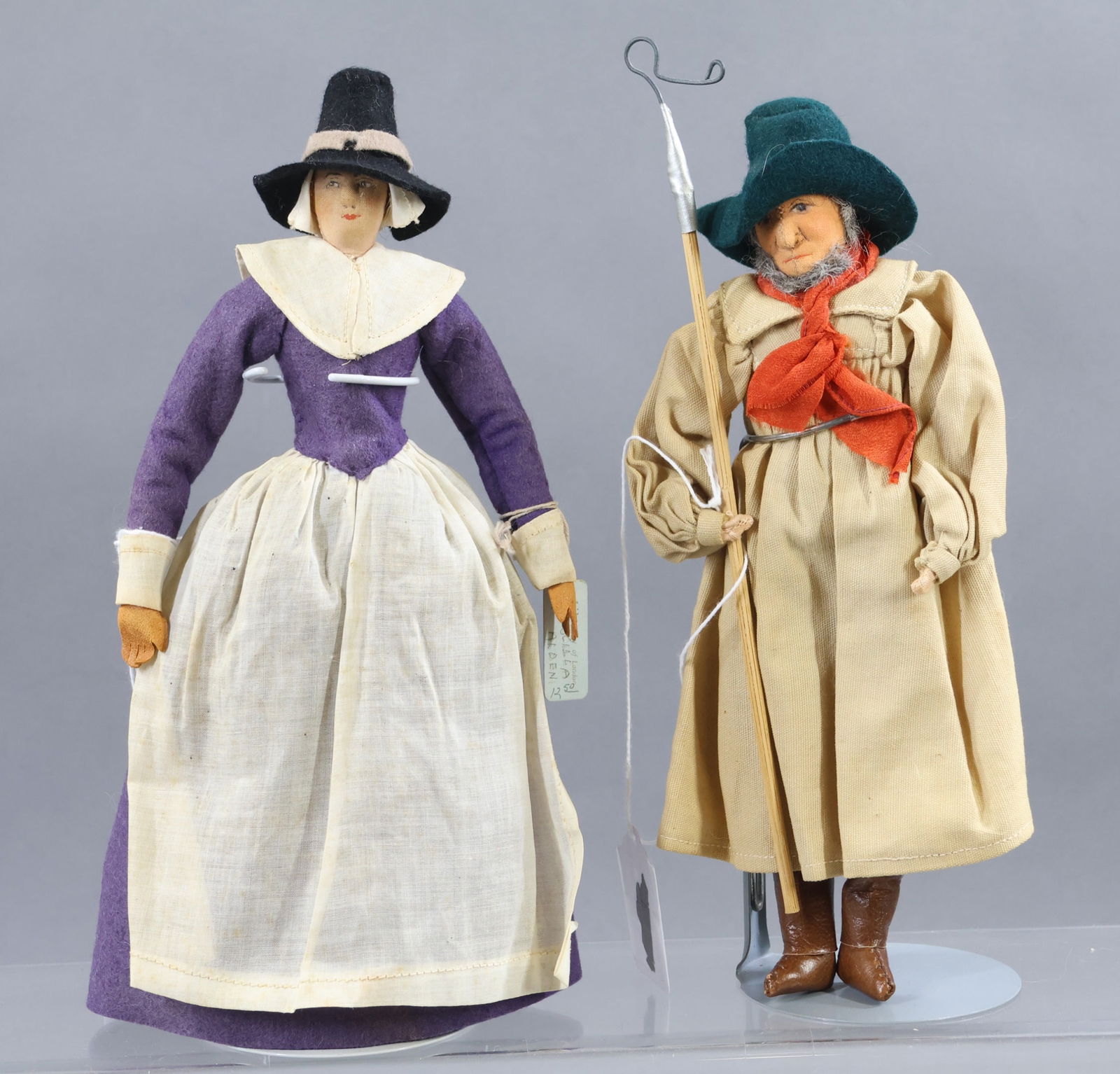 LIBERTY OF LONDON.: Pair of tagged dolls. "Priscilla Alden". She has both the cloth tag and blue hang tag. "Early Shepherd". He has the cloth tag. (2) Stands. Condition: minor age discoloration. This lot is being sold AS