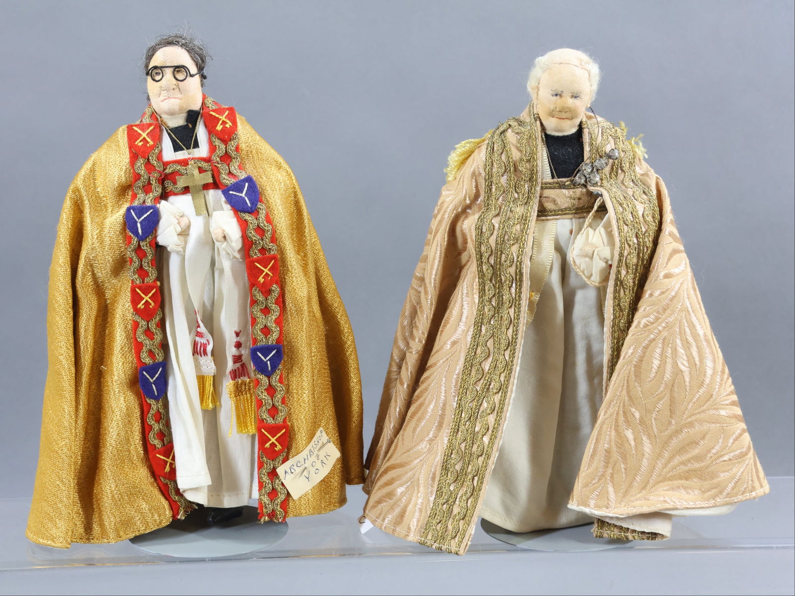 LIBERTY OF LONDON.: Pair of tagged male dolls. "Archbishop of York". "Archbishop of Canterbury" 1939 Coronation. (2) Stands. Condition: minor age discoloration. This lot is being sold AS IS.