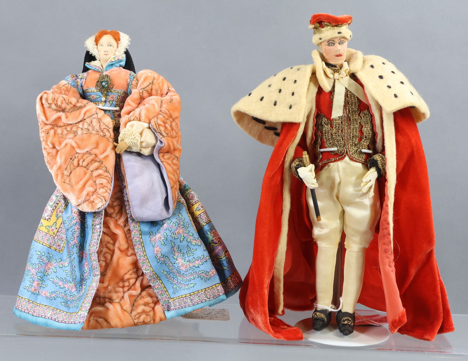 LIBERTY OF LONDON.: Pair of unmarked dolls. "Queen Elizabeth I" (with her famous red hair,) She Ruled 1558-1603. "Royal Mystery Man" doll. (2) Stands. Condition: minor age discoloration. This lot is being sold AS IS.