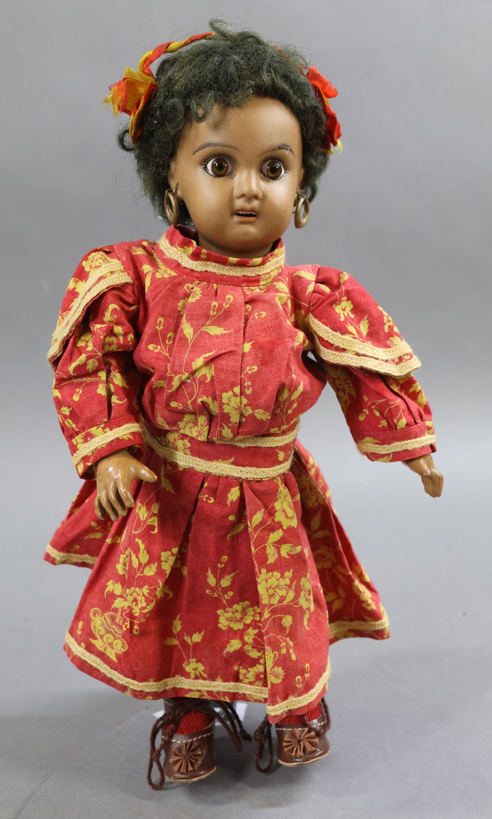 ANTIQUE FRENCH BISQUE HEAD DOLL.: 11" Mulato "2" (Jumeau) doll with brown paper weight eyes, open mouth, pierced ears, curly black mohair wig. Unmarked papier mache jointed body. Dressed in antique cotton clothing - floral print red d