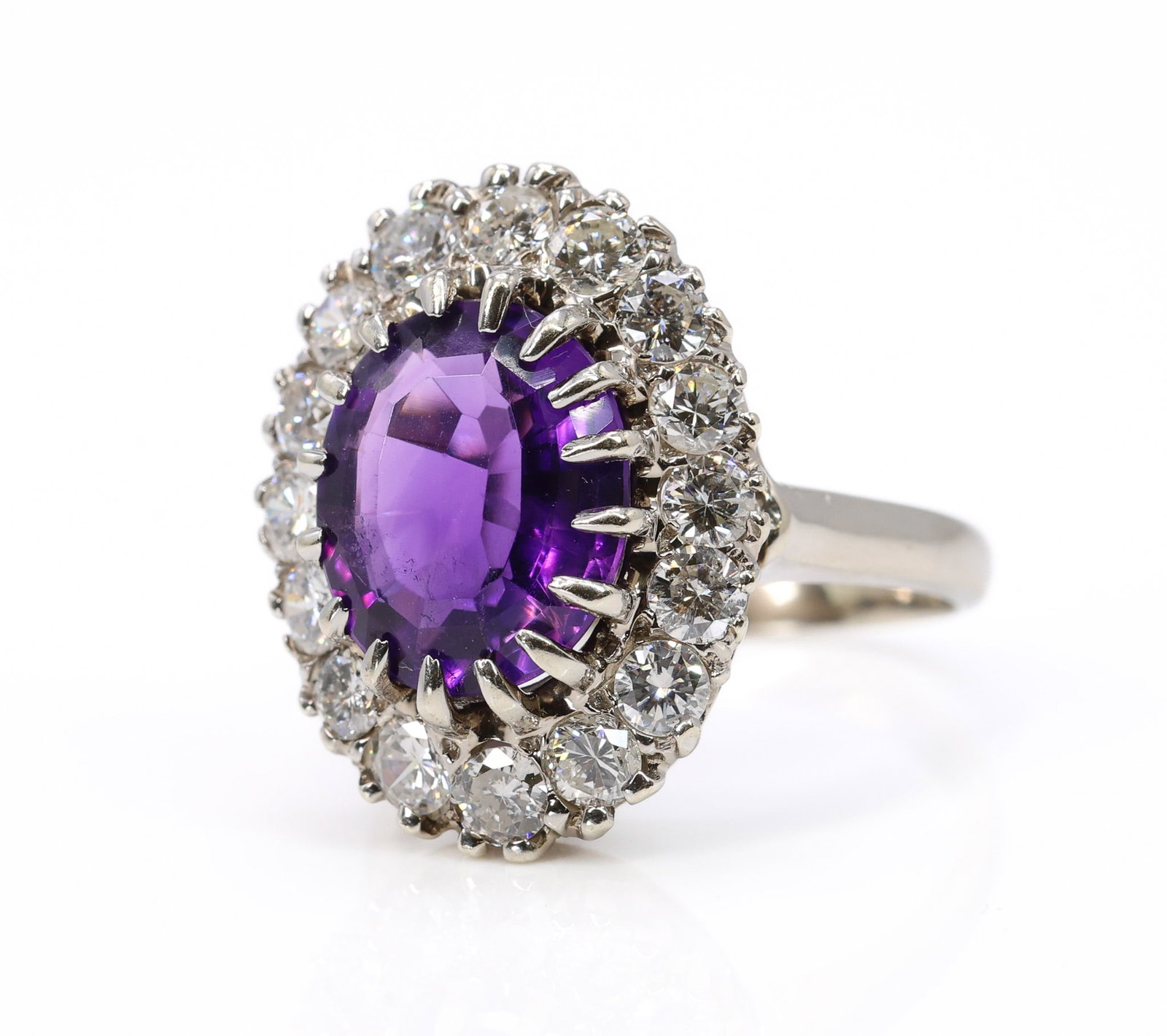 14k WG Amethyst Diamond Ring: 14k white gold amethyst and diamond halo ring, set with approx. 4.0ct oval amethyst surrounded by approx. 1.6ctw round brilliant cut diamonds. Size 7.25 and 4.9dwt.