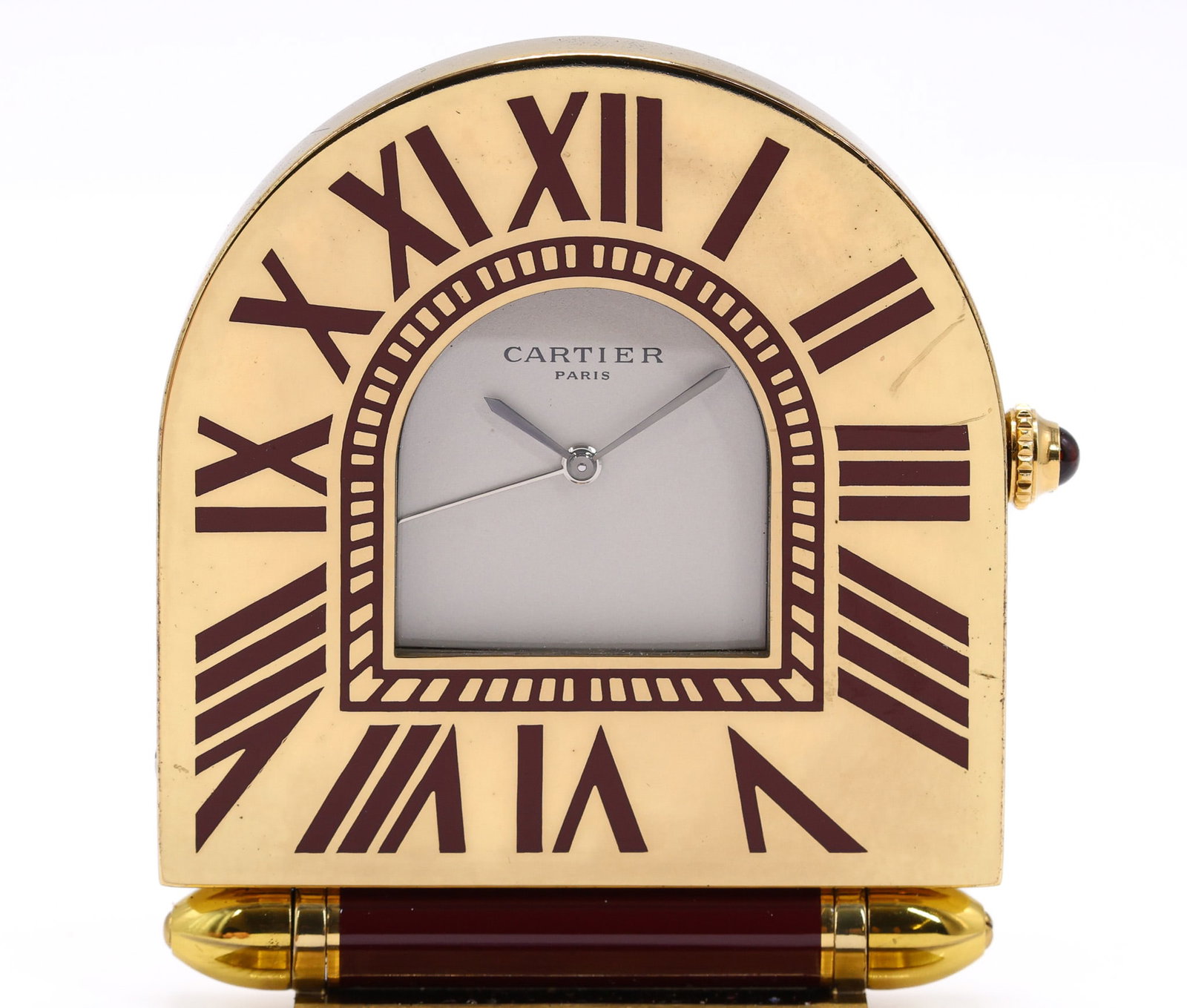 Cartier Travel Clock: Cartier Paris travel clock with cream dial and burgundy Roman numerals, quartz movement, arched case with gilt metal base, signed dial. Includes original pouch. 2.25"h.