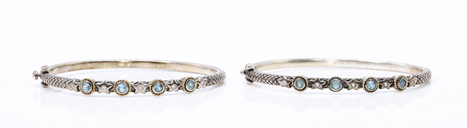 Andrea Candela 18k/Sterling Topaz Diamond Bracelets: Pair of Andrea Candela 18k gold and sterling silver bracelets set with round blue topaz and small accent diamonds in star motifs, with rope-twist detailing and hinged closures. 6.75" and 26.1dwt