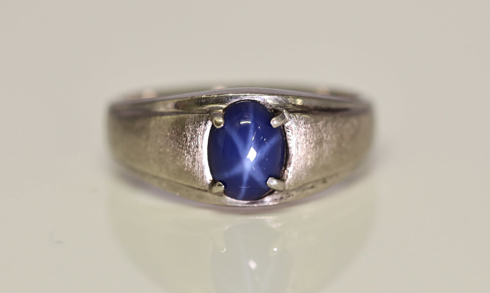 10k YG Star Sapphire Ring: 10k white gold ring set with an oval cabochon star sapphire measuring approx. 8mm x 5.9mm, size 9.25, 2.2dwt.