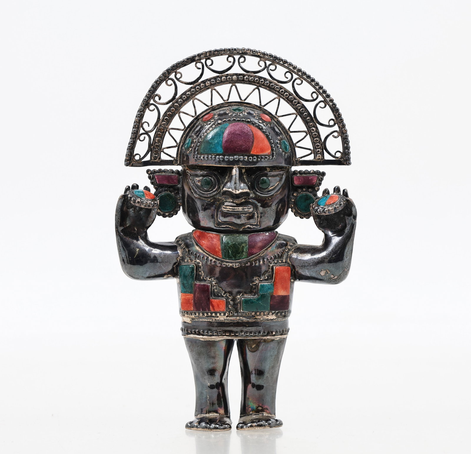 Peruvian 950 Silver Sculpture: Peruvian 950 silver sculpture of the god Naymlap, with an openwork and filigree headdress and inlaid faux gemstones. Marked to the foot. 5.25”h x 3.25”w x 1.25”d, and 3.81 ozt