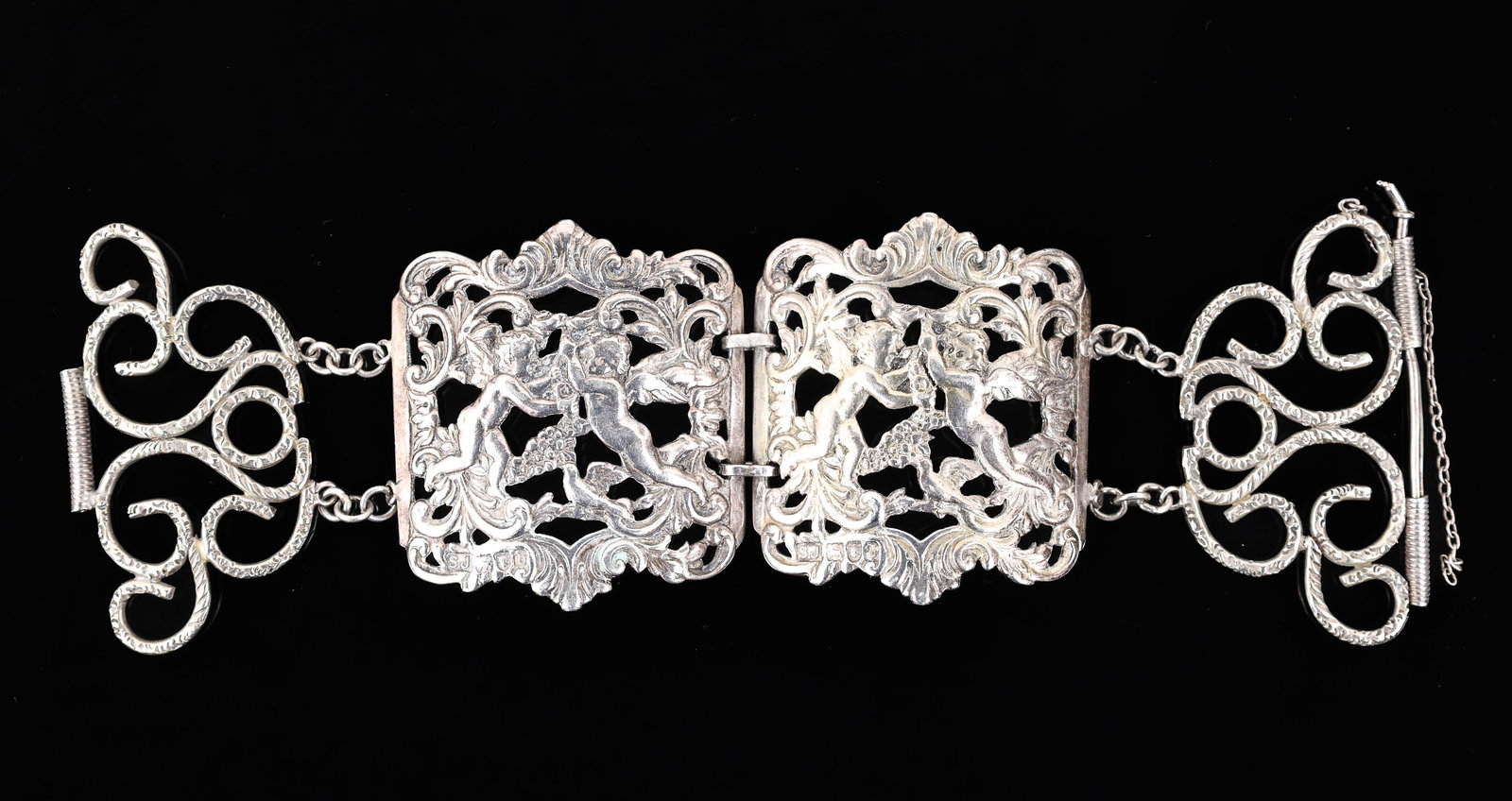 Victorian British Sterling Silver Shoe Buckle Bracelet: Victorian British sterling silver pair of shoe buckles, with openwork decoration depicting puttis, grapevines, and scrolling foliage, converted into a bracelet with the addition of silver plated