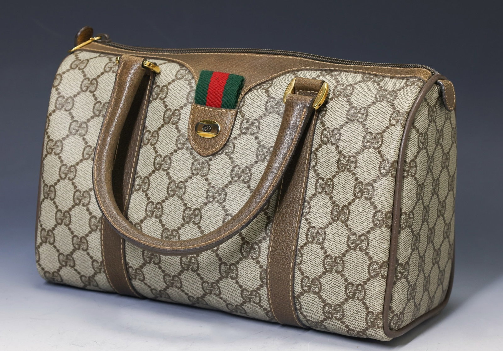 Vintage Gucci Monogram Handbag from the Accessory Collection: GG Monogram coated canvas with leather trim and handles, interior zipper pocket, stamped logo on hardware and distinct web stripe. Small handbag from Gucci's Accessory Collection, also referred to as