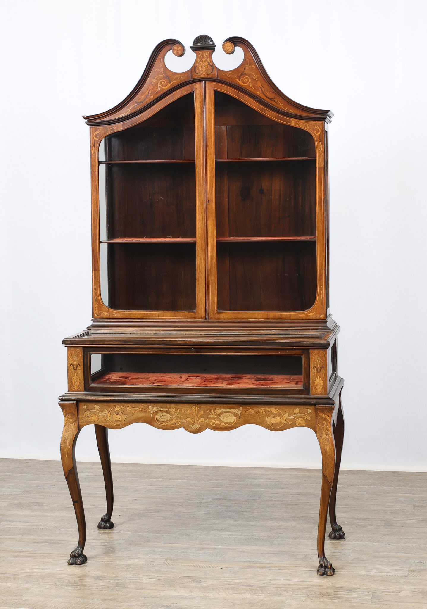 Marquetry and Inlaid Display Cabinet: Two-part cabinet, mahogany case with satinwood floral and foliate scrolled marquetry with banded inlay, scrolled pediment with fan centerpiece, two glazed doors with red velvet shelving over one glass