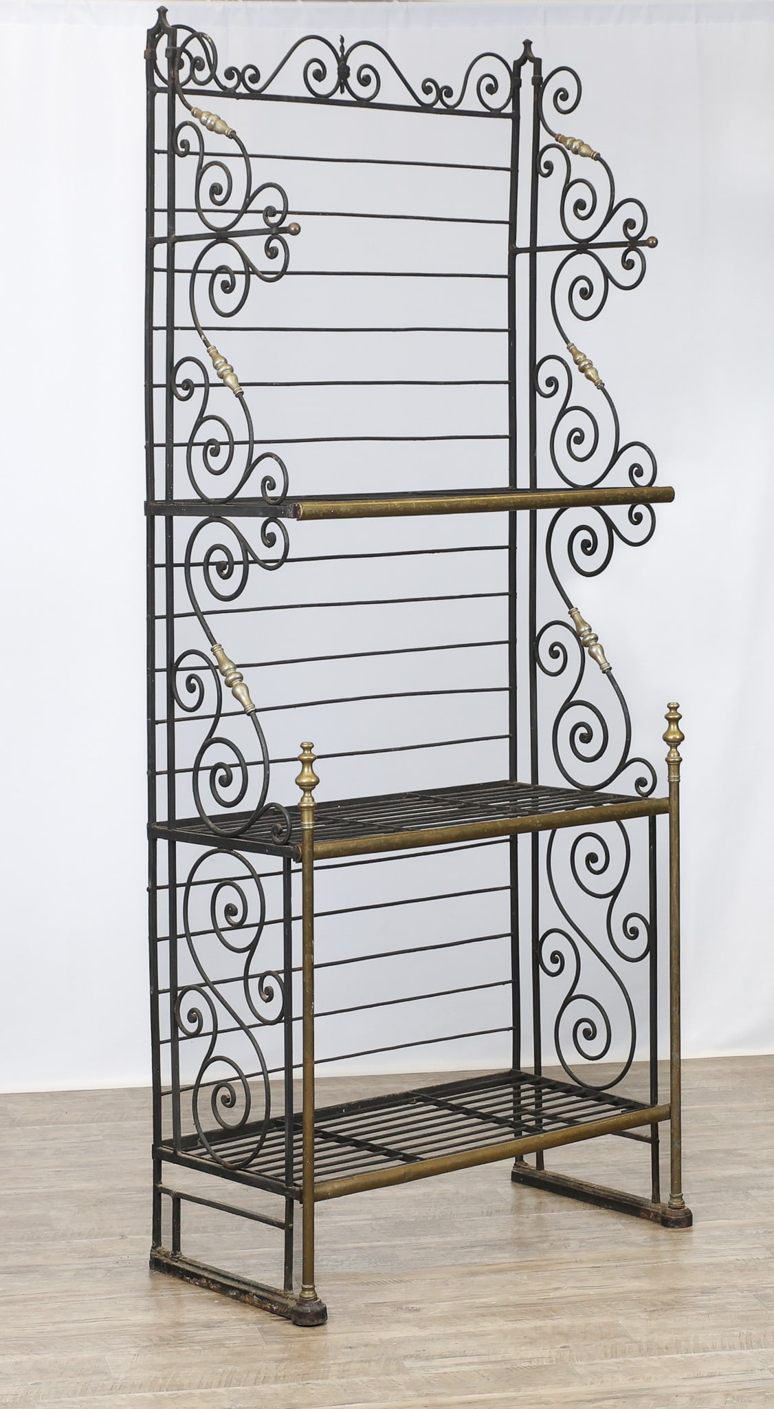 French Wrought Iron and Brass Baker's Rack: Scrolled decoration along the crest and sides, lattice back and shelving on turned brass pillars and plinth legs. Late 19th c. 92"h x 38.5"w x 19"d