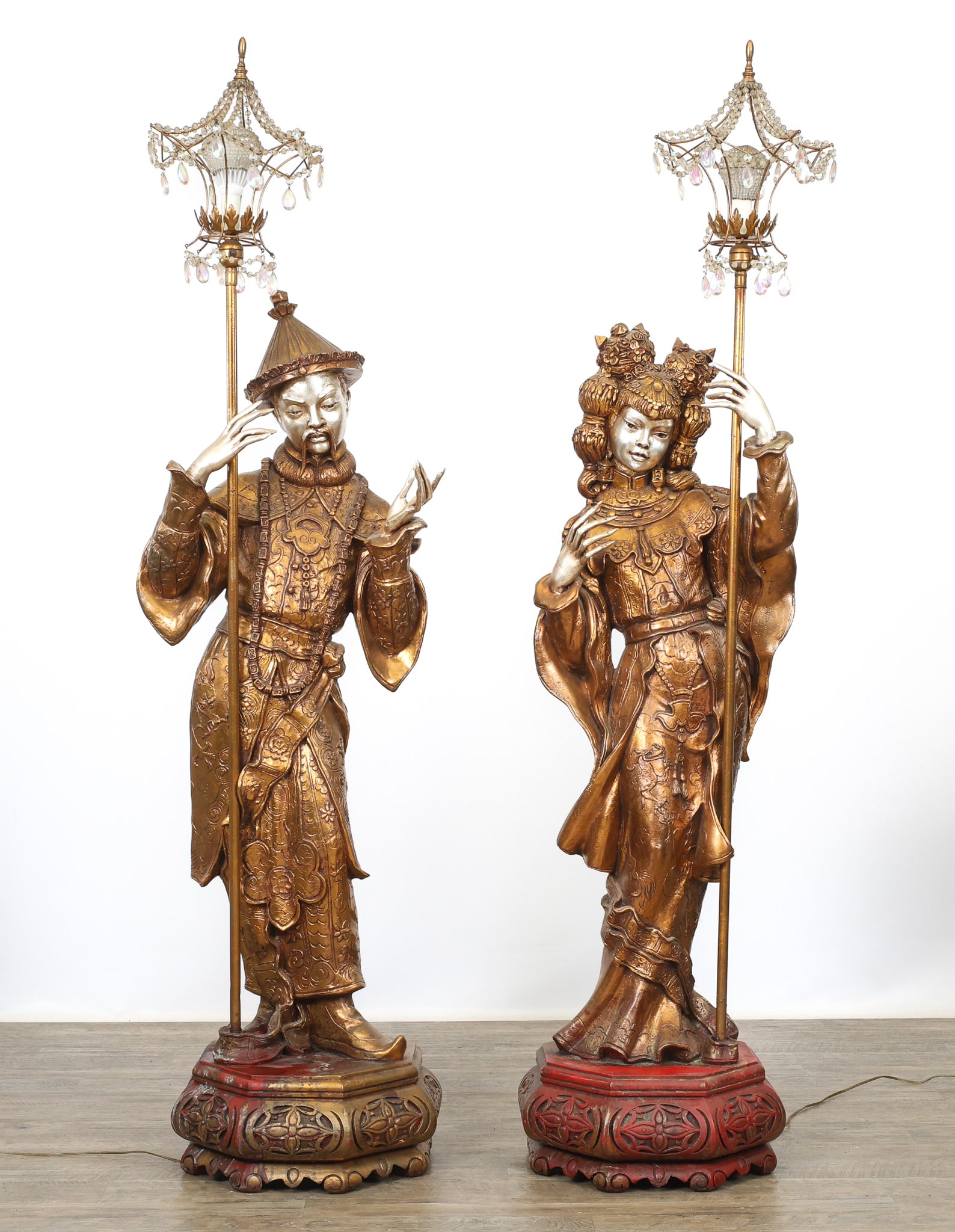 ARP Chinoiserie Torchiere Floor Lamps: French chinoiserie torchiere floor lamps, composite plastic in gold and silver with red accents, in the form of male and female courtiers, each holding a lantern with strings of faceted prisms around