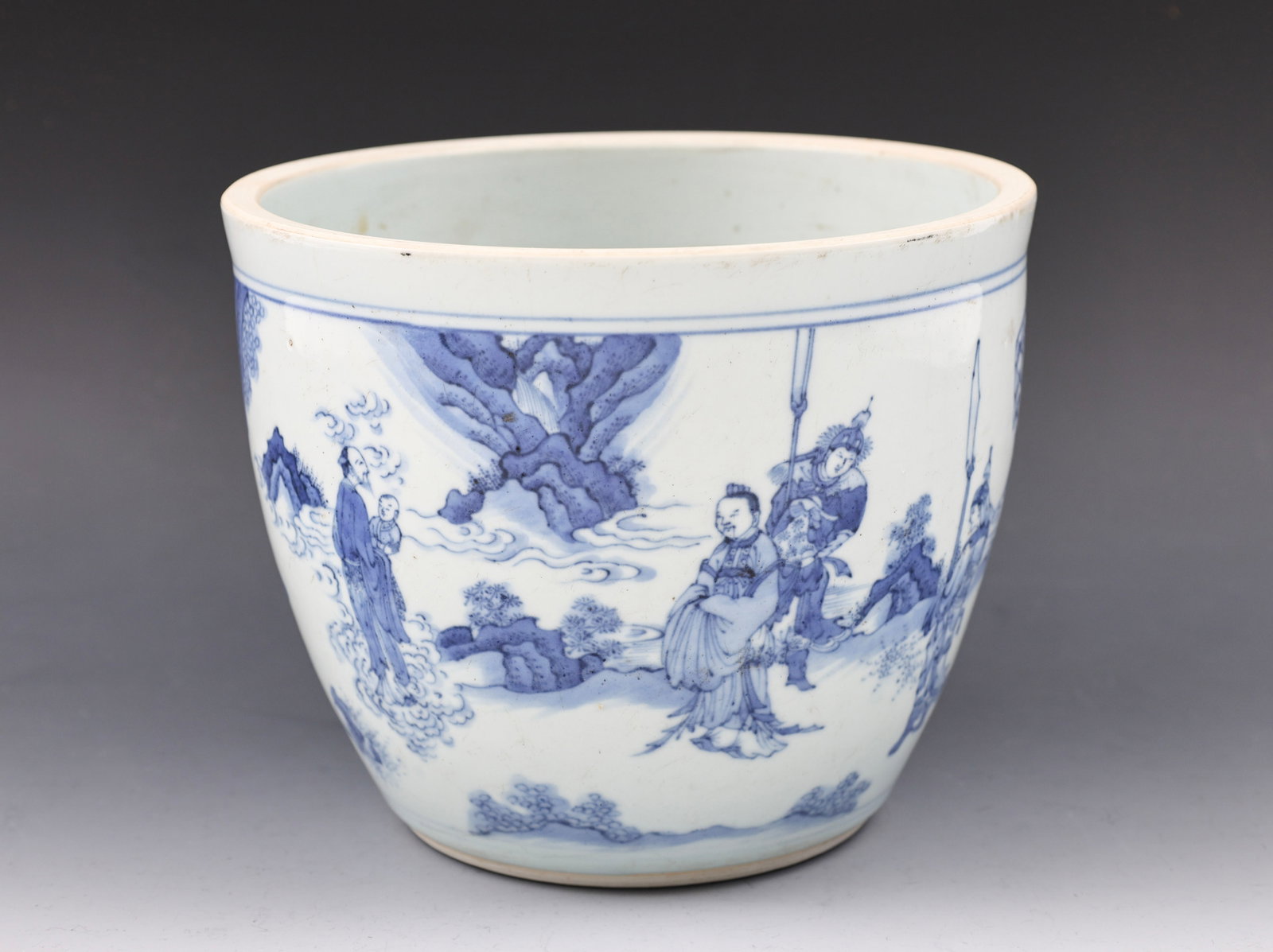 Chinese Blue and White Porcelain Cachepot: Qing era blue and white porcelain cachepot depicting a court official with attendants meeting a man holding a child in his arms, possibly representing the Immortal Fuxing, in a mountain landscape with