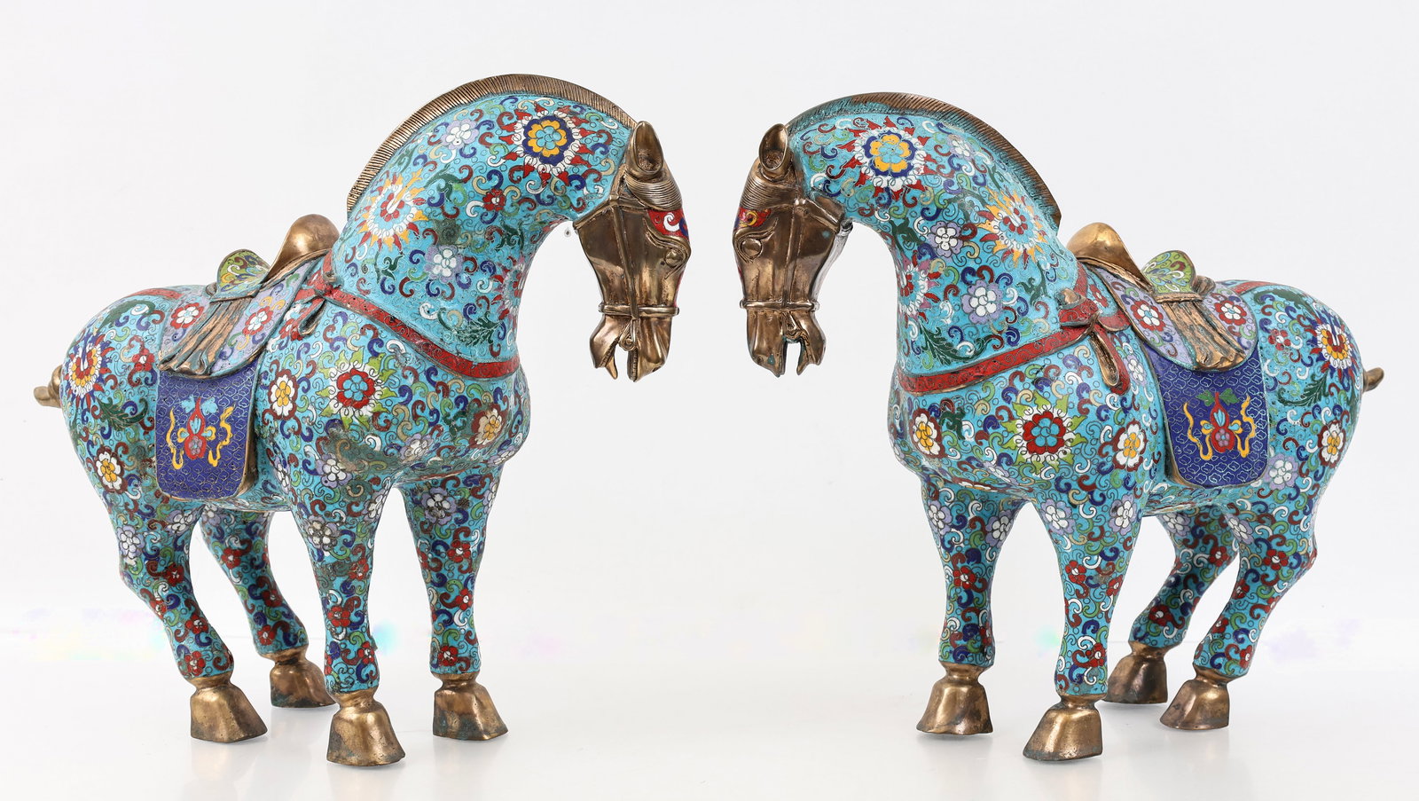 Chinese Cloisonne Tang Horses: Republic era pair of cloisonne Tang horses decorated with floral and treasure motifs. Spurious Qianlong marks to the undersides. (2) horses. 15"h x 8"w x 18"d