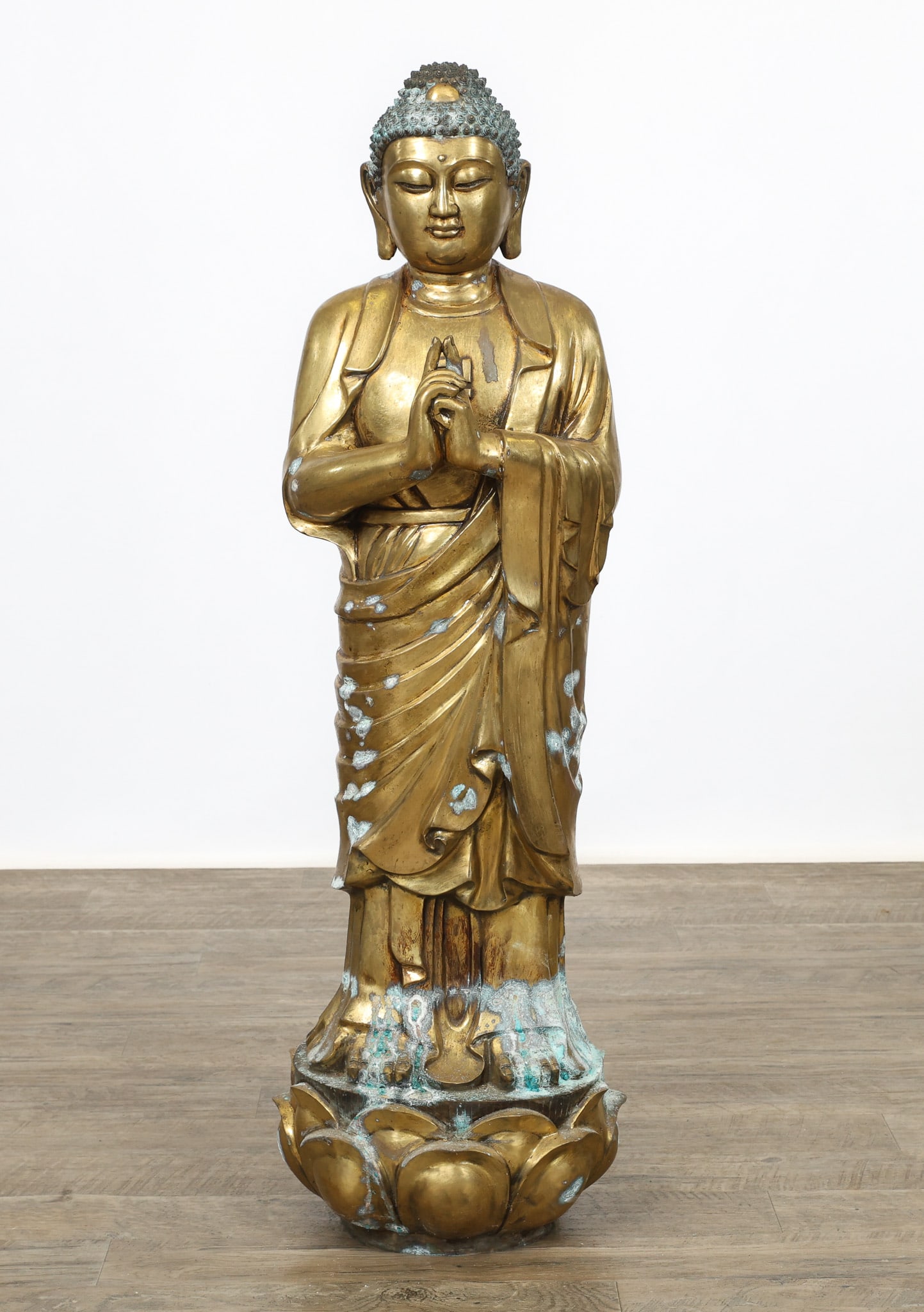 Chinese Bronze Amituofo Buddha: Qing or later gilt bronze sculpture of Amituofo Buddha forming a mudra while standing on a lotus leaf. Spurious Xuande seal mark to the base. 40"h x 12"w