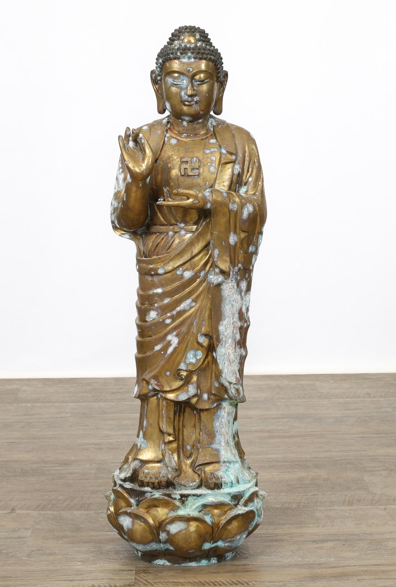 Chinese Bronze Amituofo Buddha: Qing or later gilt bronze sculpture of Amituofo Buddha forming a mudra while standing on a lotus leaf. Spurious Xuande seal mark to the base. 40"h x 12"w
