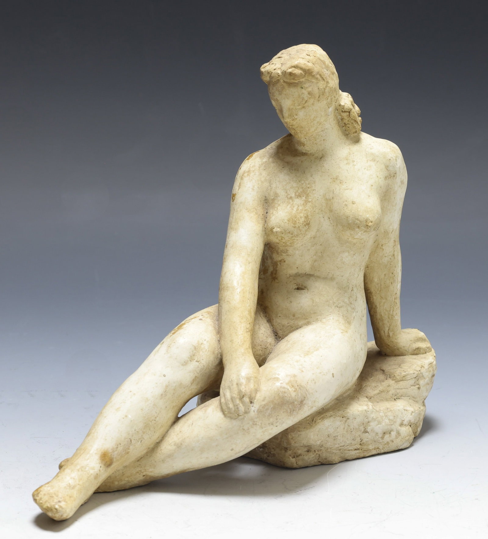 Charles Rudy (1904 - 1986): Plaster sculpture of a nude female sitting on a rock. Impressed signature to the base en verso with artist's cipher, dated 1940. 7.5"h x 9"w x 3"d