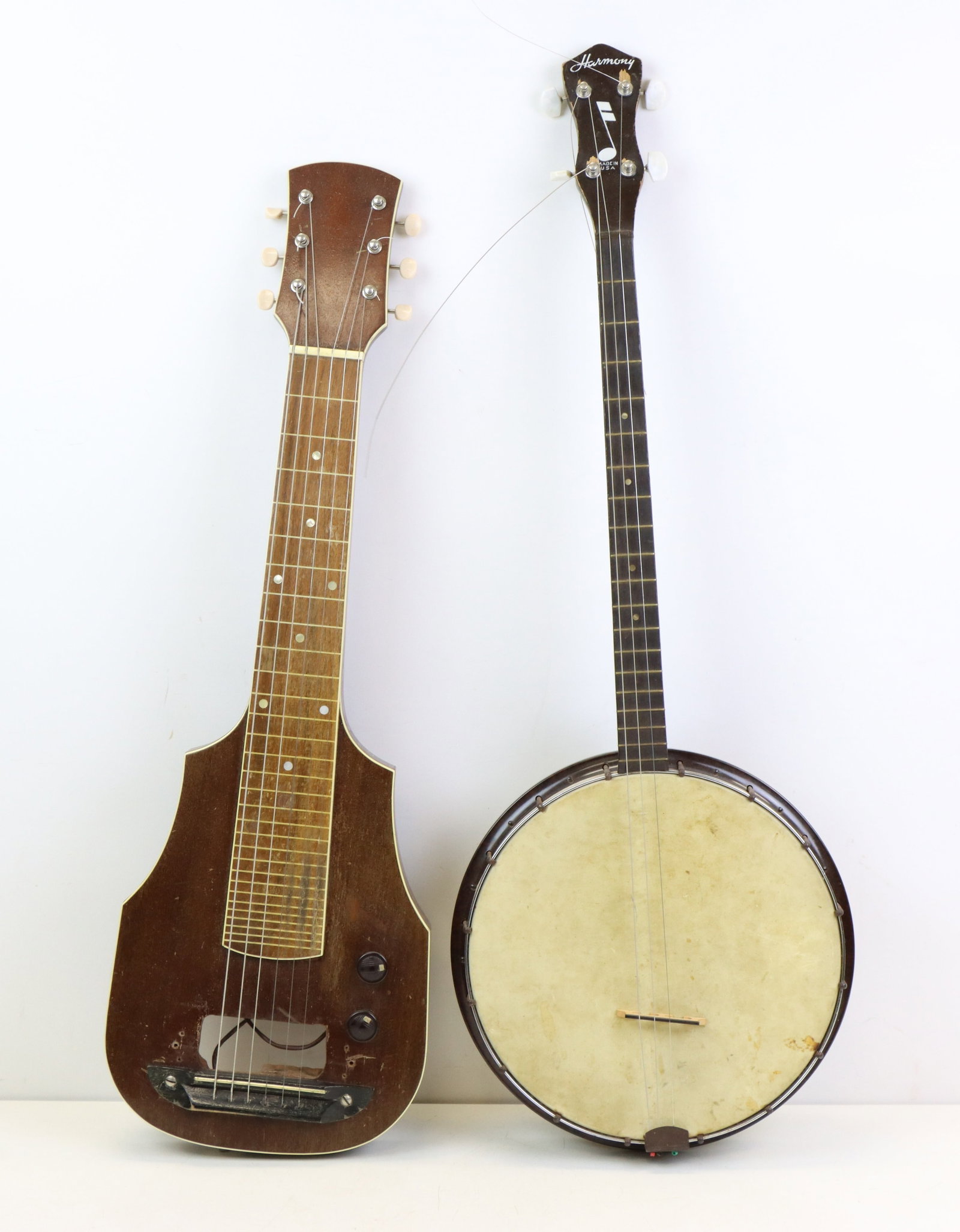 Lot of 2 Instruments. Lap Steel and Tenor Banjo: Unlabeled Lap Steel Guitar. Not Working with Electronic Parts in Case. Partially Disassembled. Original Bakelite Knobs, Harnony Tenor Banjo. Chicago USA.c.1970. Styrene Plastic Body. Lowering Bridge W