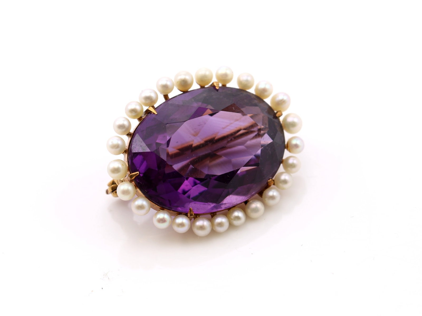 14k YG Amethyst Pearl Brooch: 14k yellow gold brooch set with one oval cut amethyst weighing approximately 19.00 carats and twenty-five seed pearls measuring approximately 2.5mm.